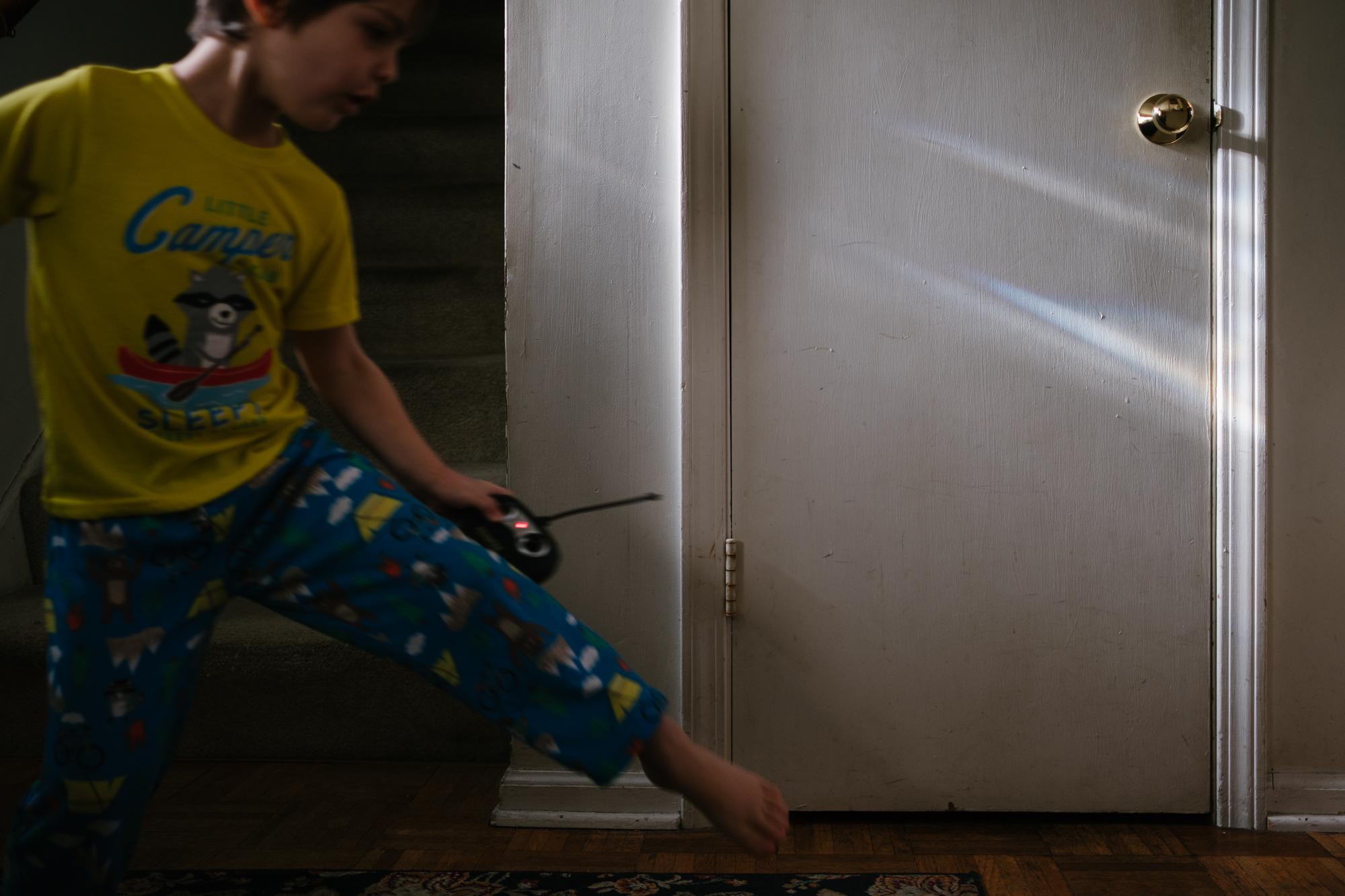boy jumping in dark hallway - Documentary Family Photography