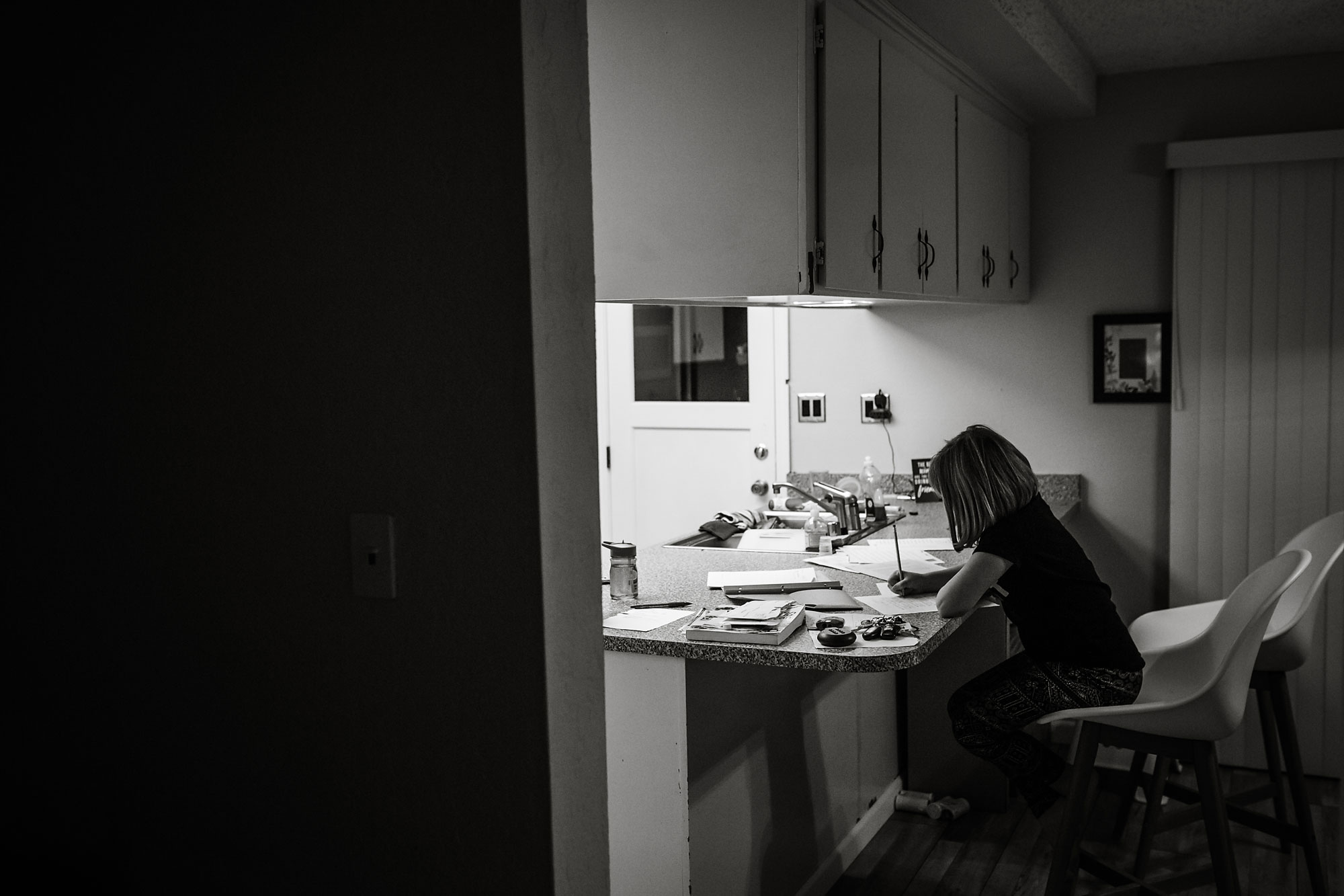 girl doing homework at table - documentary family photography
