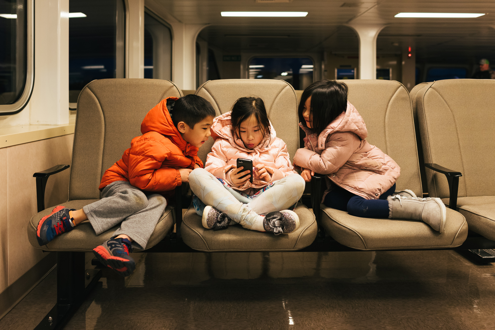 kids with phone on ferry - documentary family photography