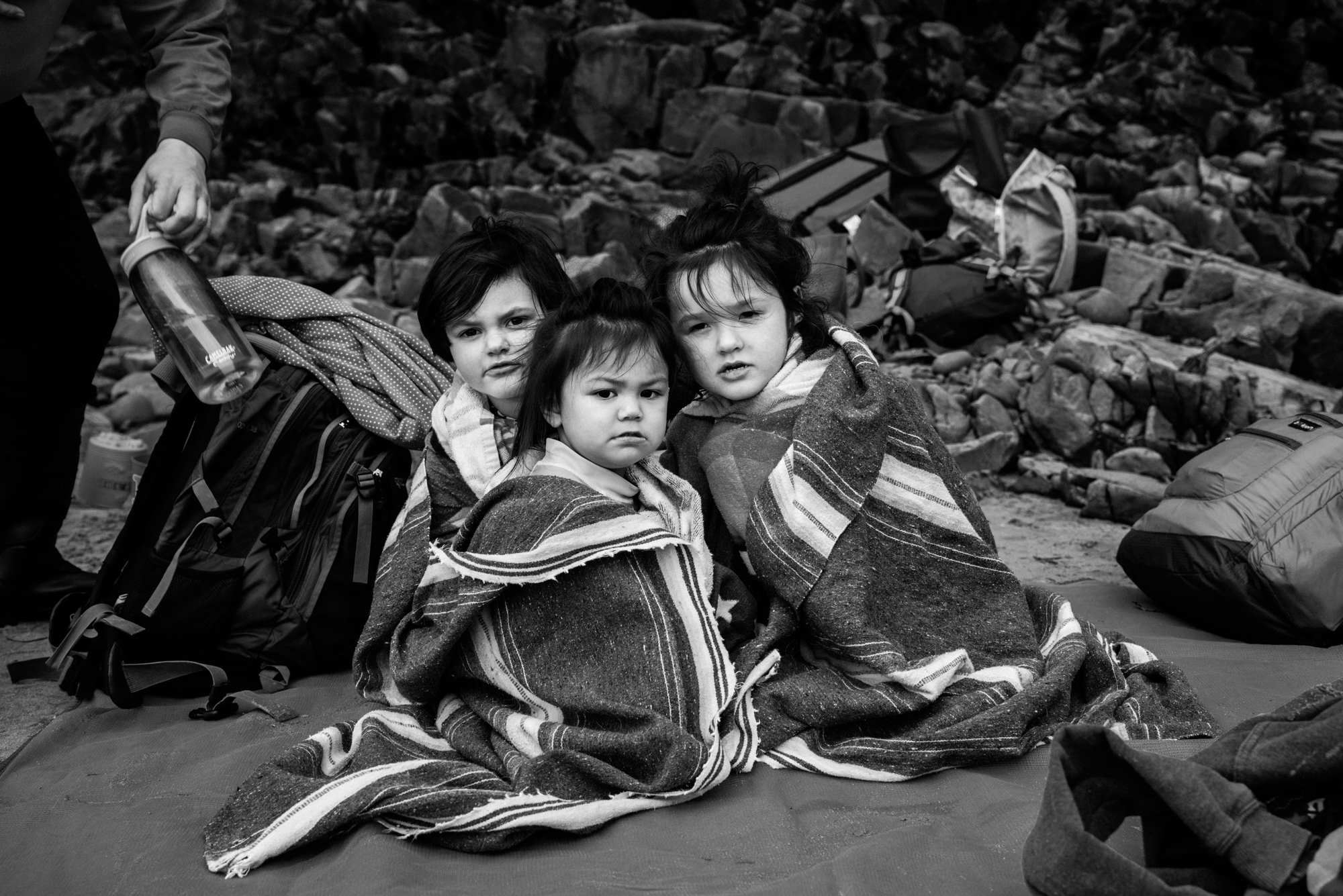 kids huddled in towels on beach - documentary family photography
