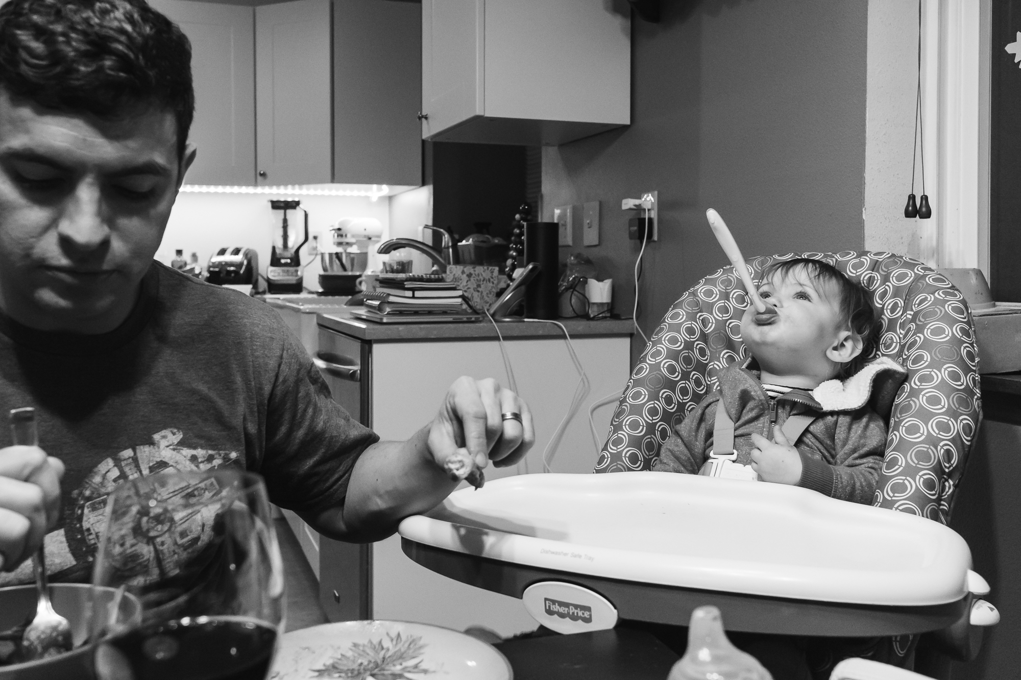 baby girl plays with spoon at dinner - documentary family photography