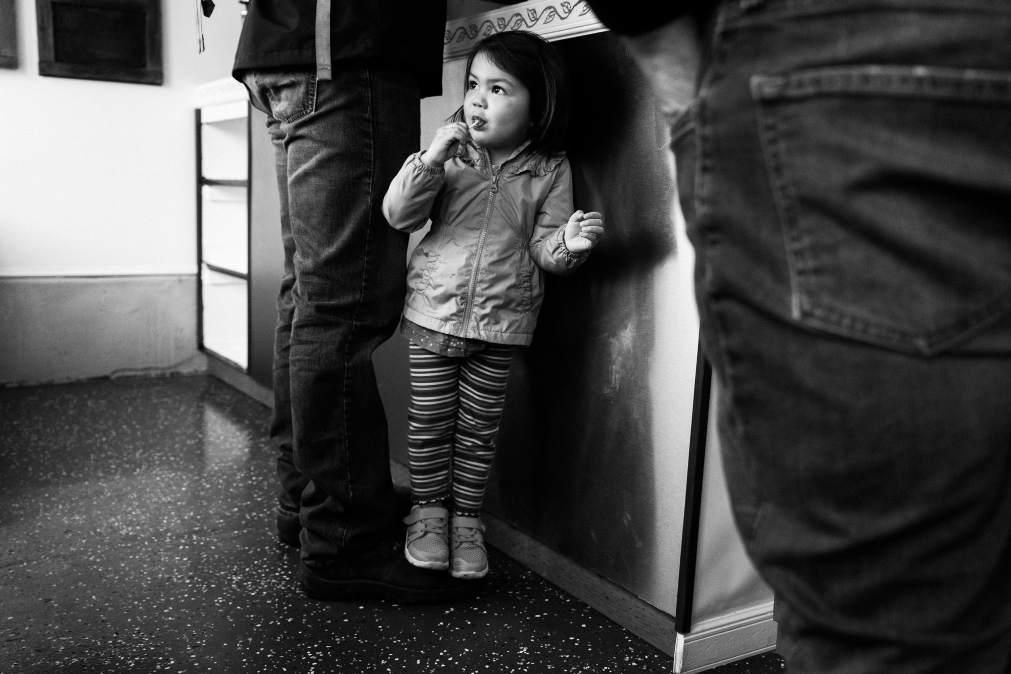 girl with sucker waiting at counter - Documentary Family Photography