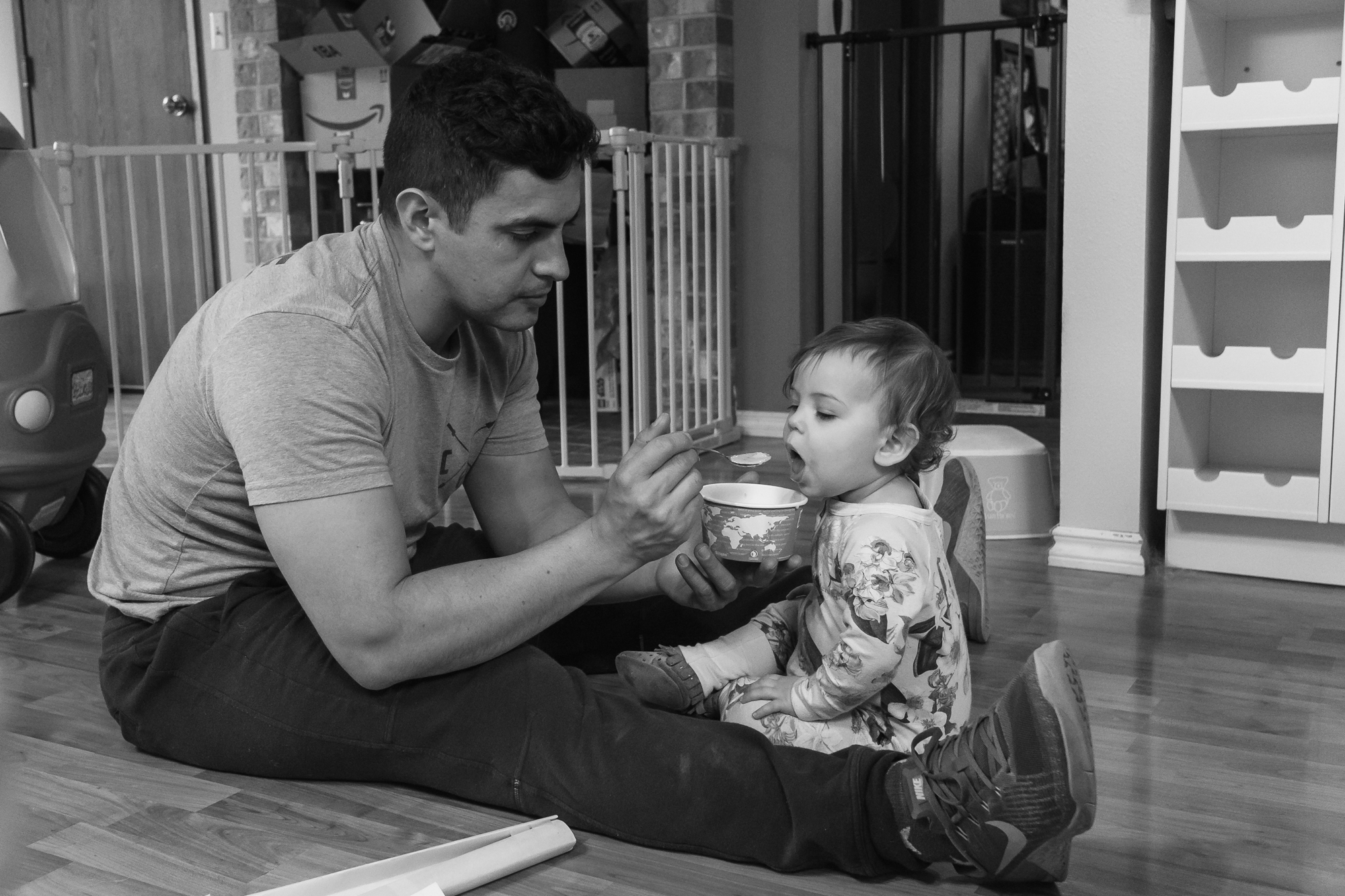 father feeds baby on floor - Documentary Family Photography