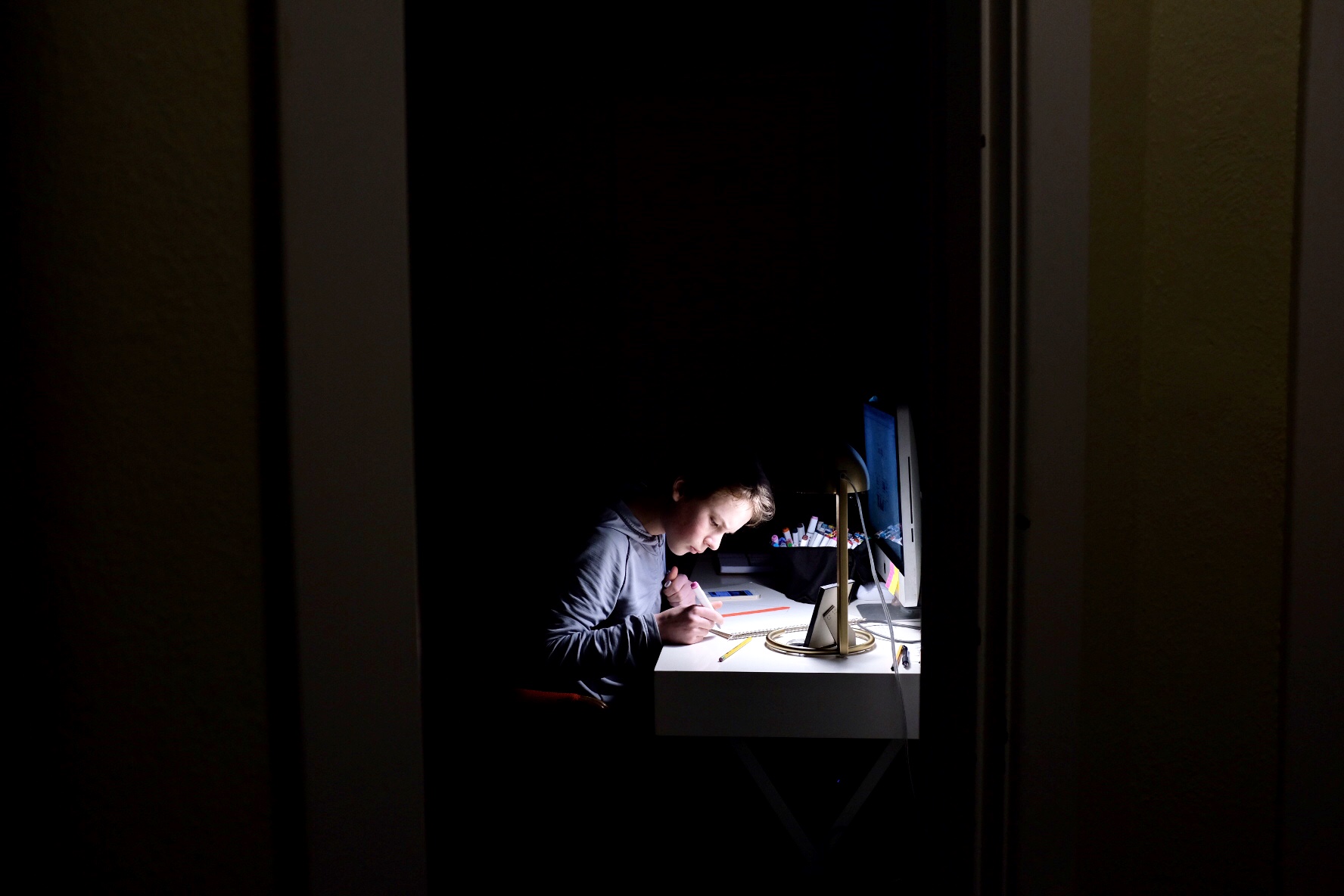 boy working under desk lamp - Documentary Family Photography