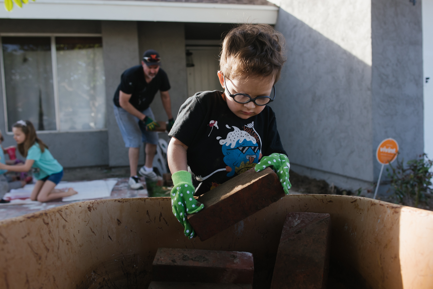 boy helps with brick work - Documentary Family Photography