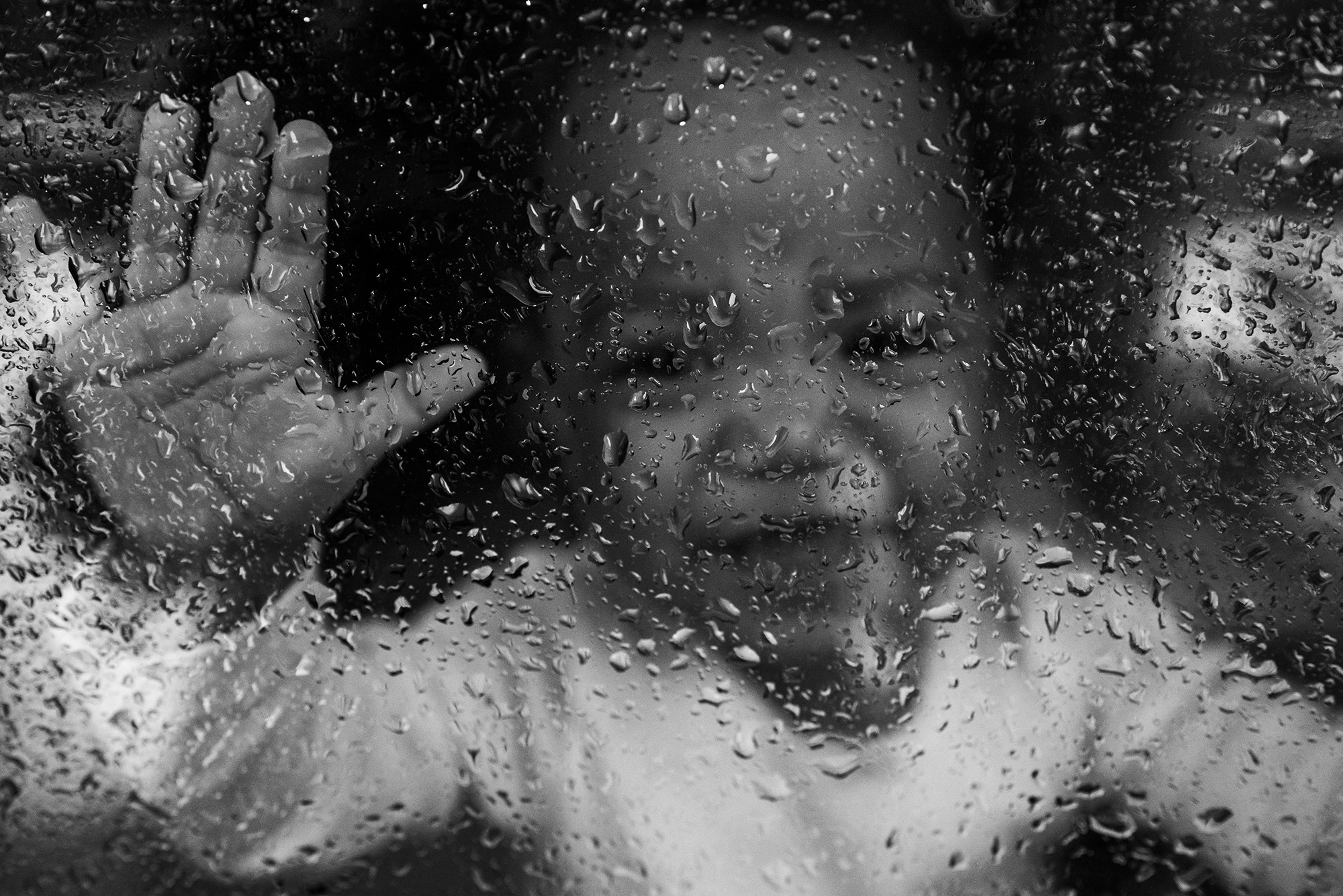 baby through window with rain - Documentary Family Photography