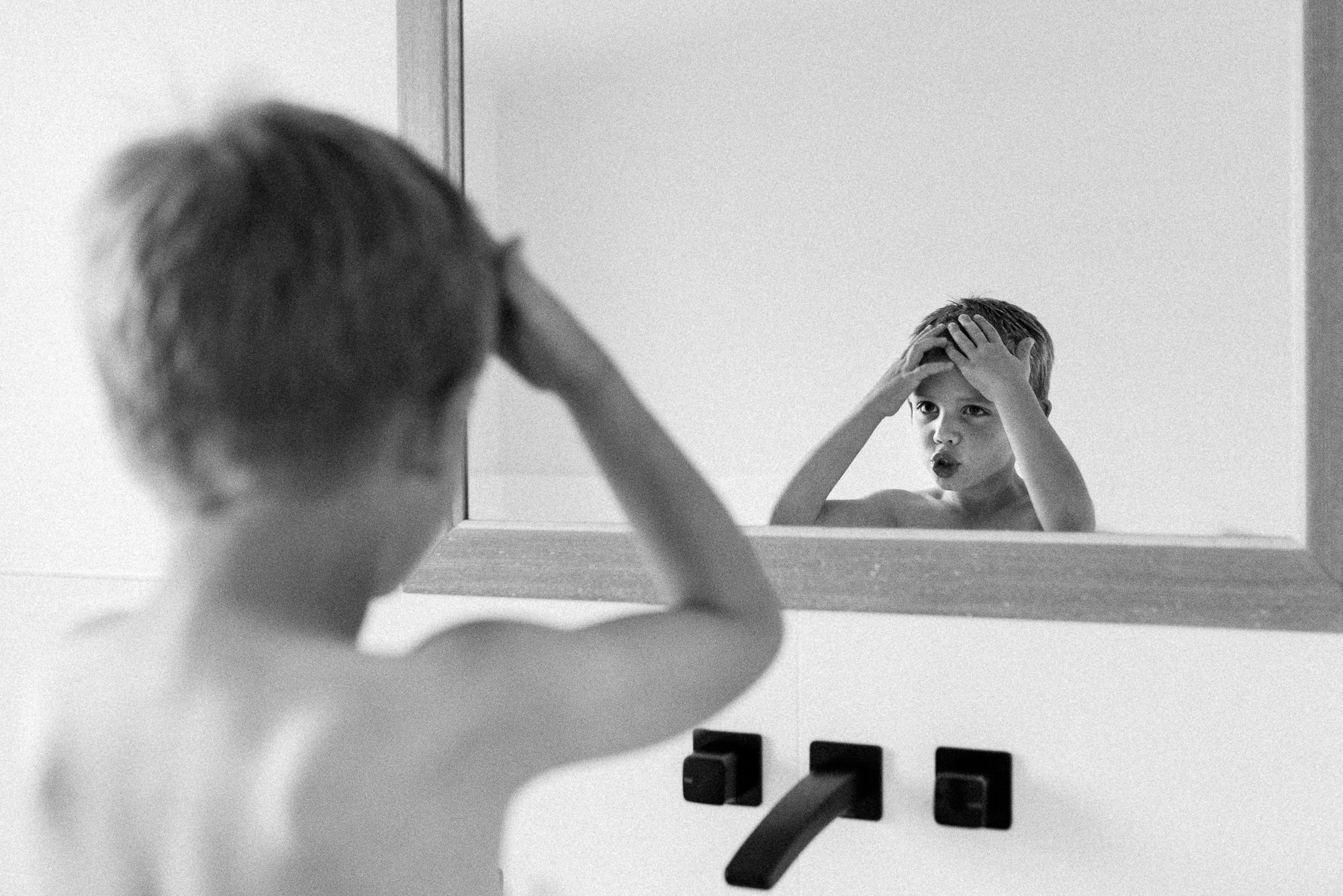 boy in mirror looking stressed - Documentary Family Photography