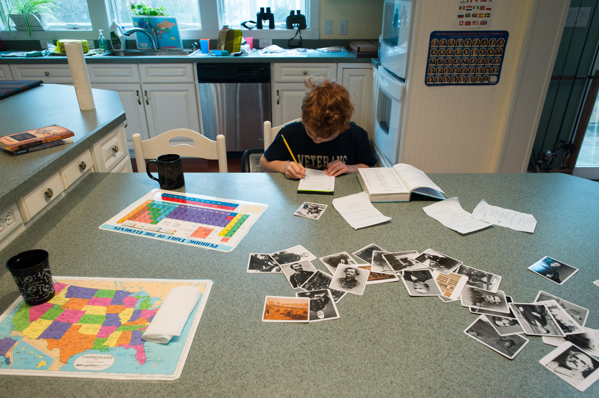 boy doing homework at counter - Documentary Family Photography