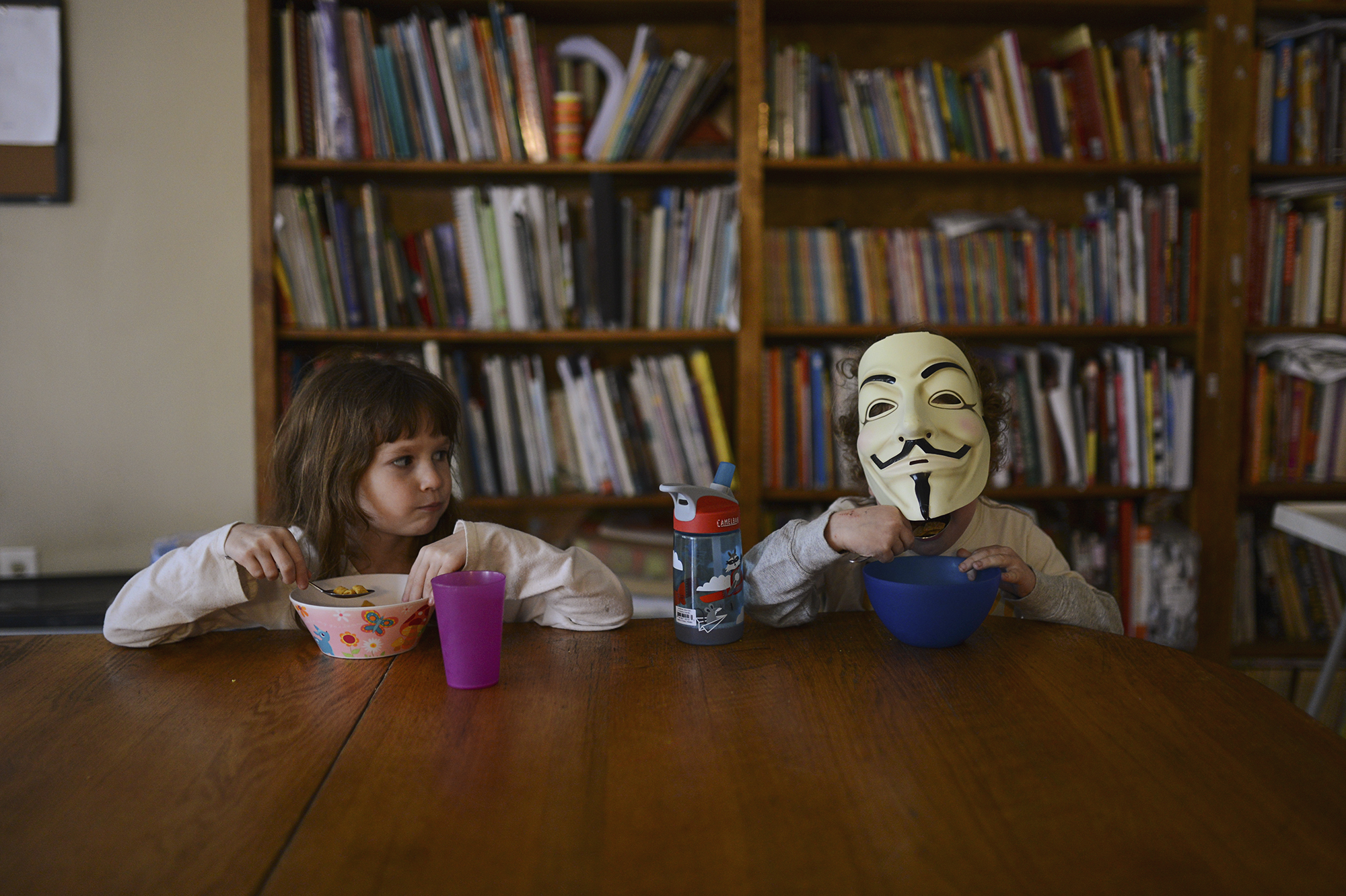kid with mask on at dining table -documentary family photography