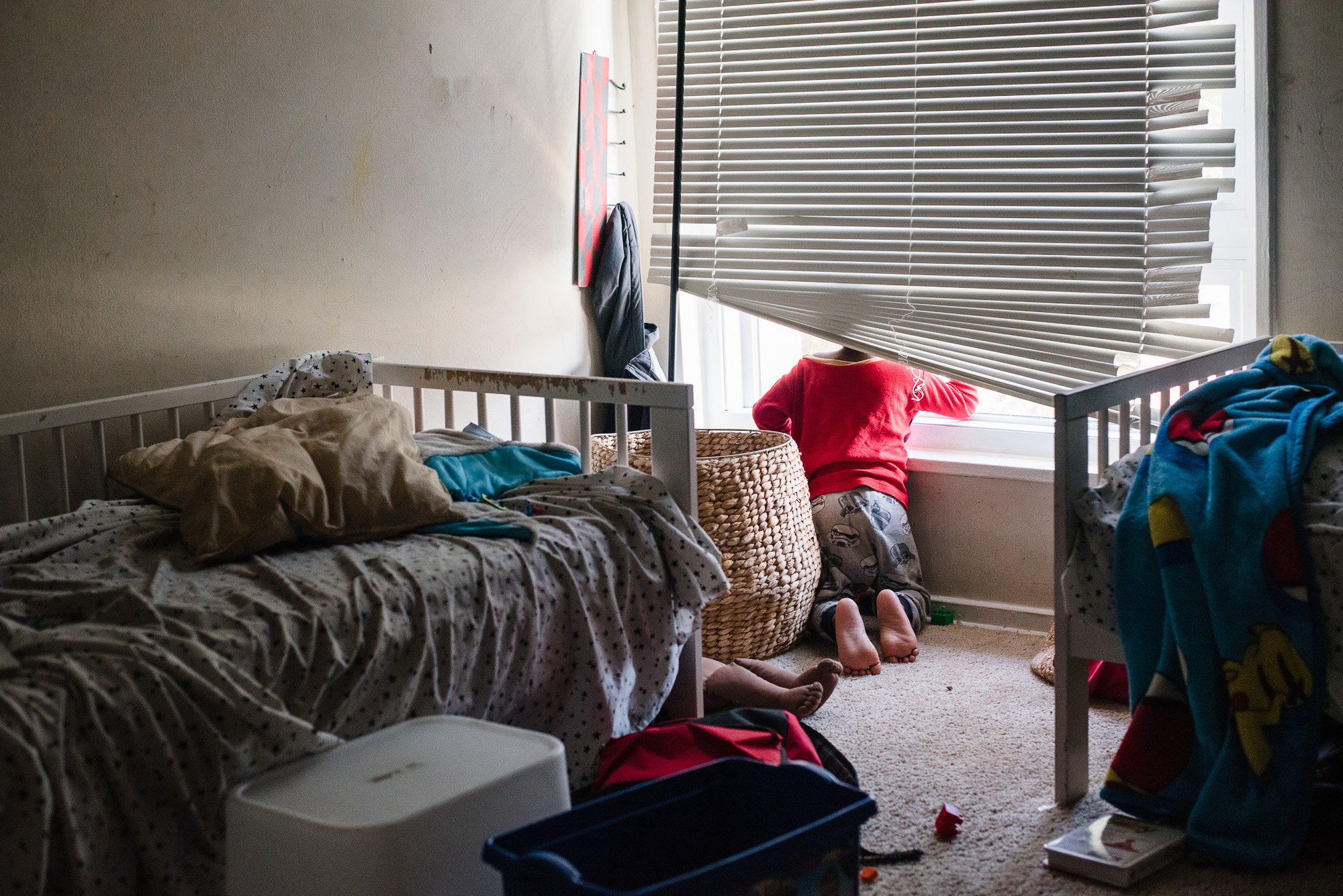 child looking out window - documentary family photography