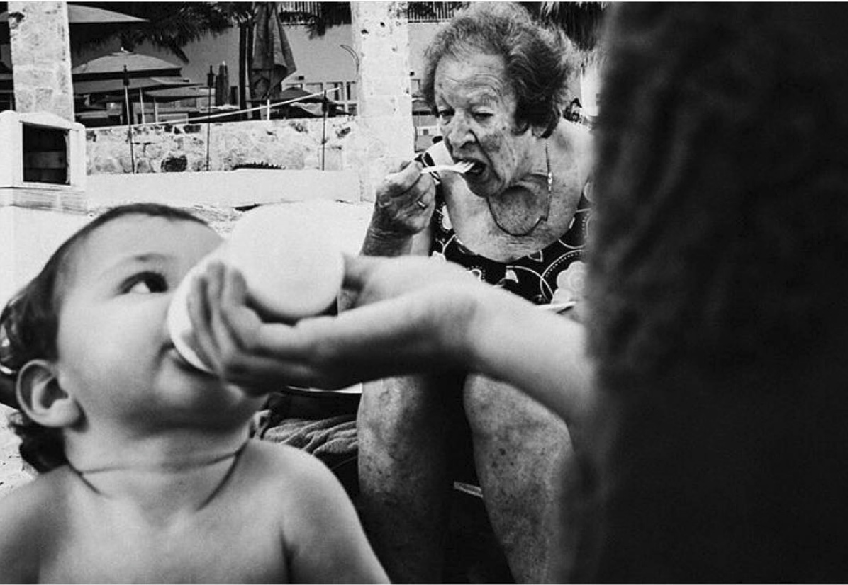 old woman eating with baby eating in foreground