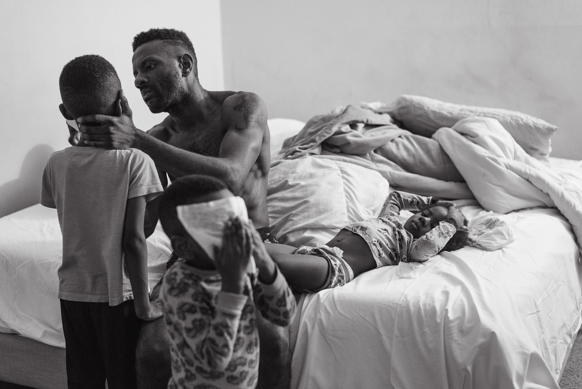 father examining son's face - Documentary Family Photography