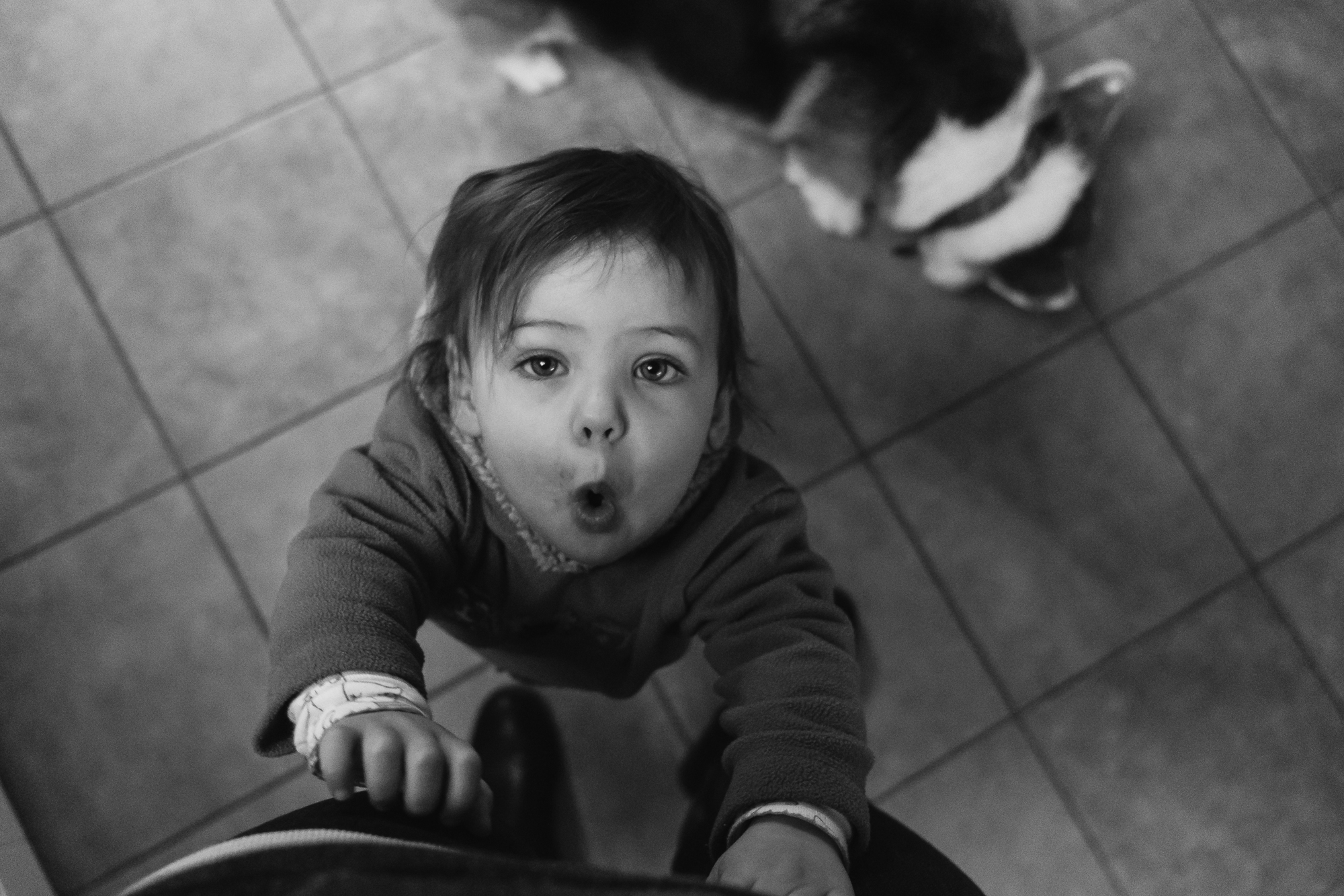 girl reaches for mom and makes face -Documentary Family Photography