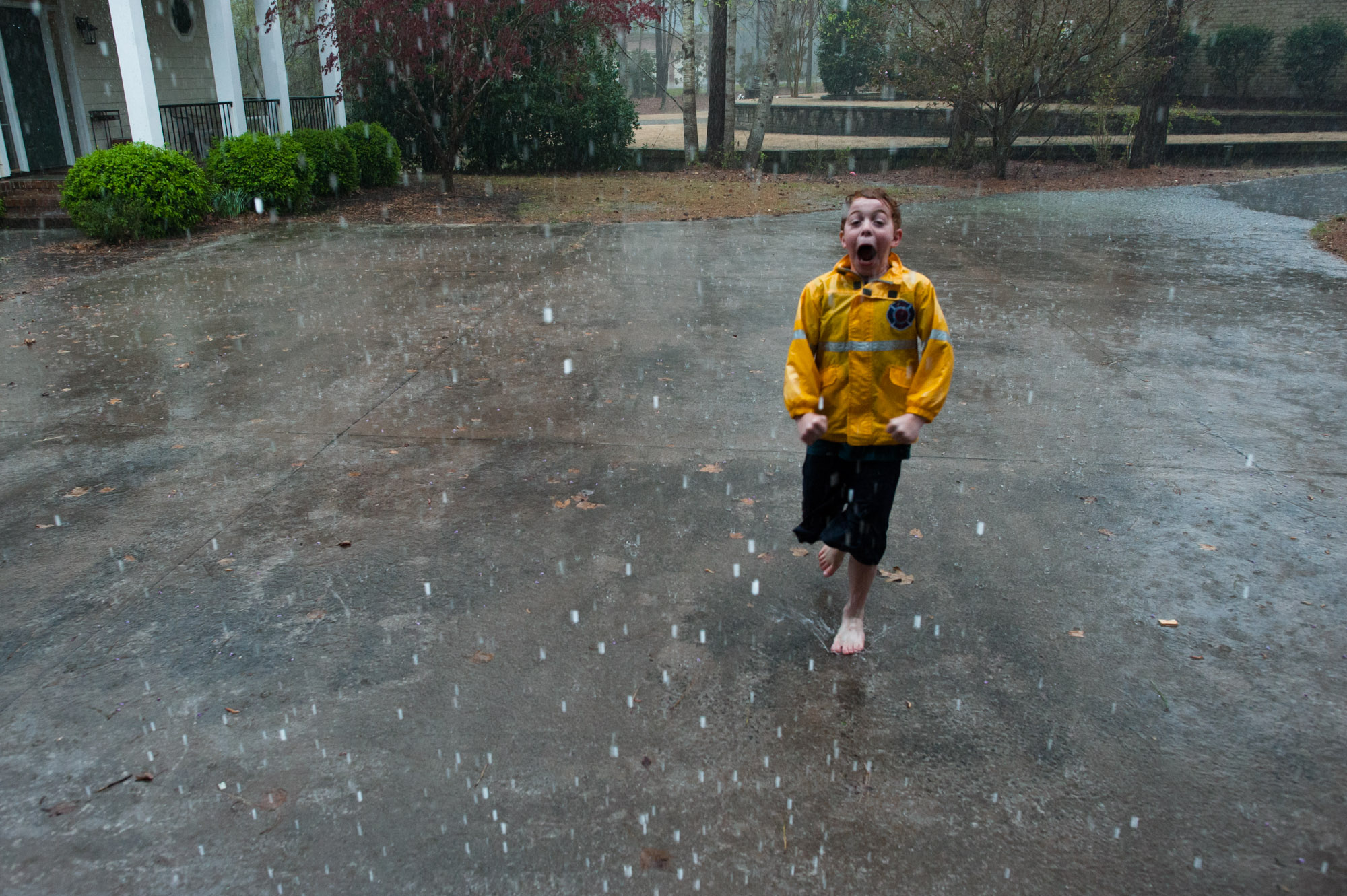 boy plays in rain - documentary family photography