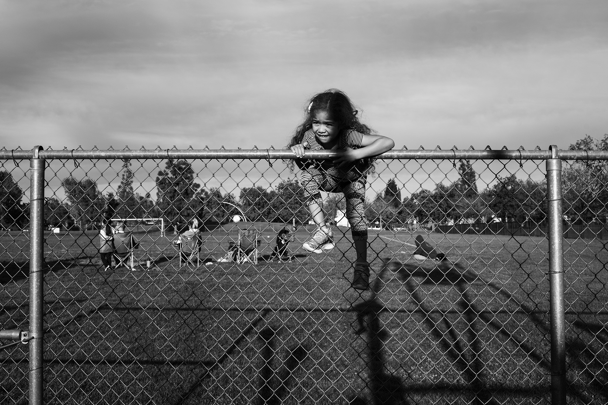 girl climbing fence - documentary family photography