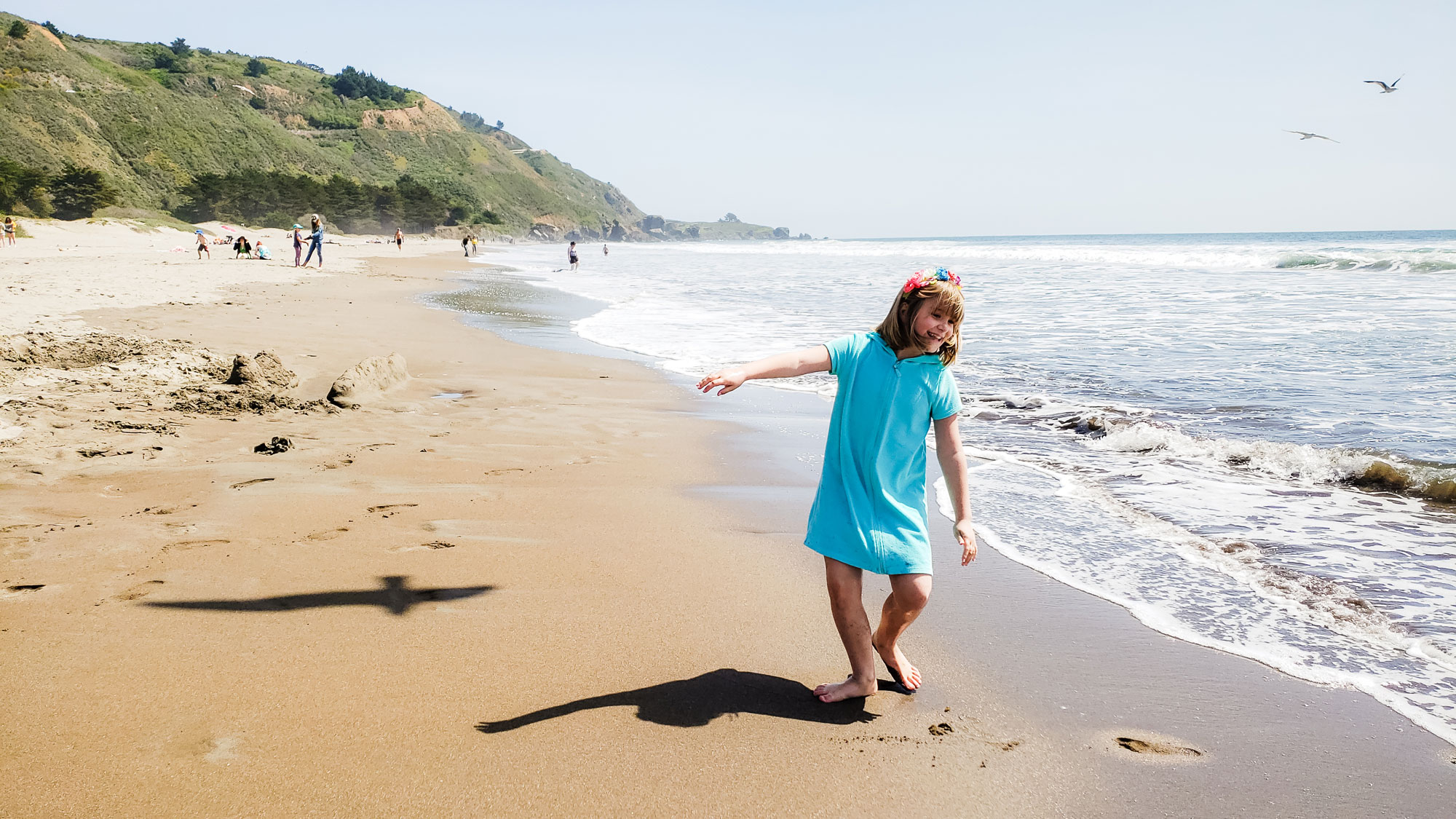 girl dances on beach - documentary family photography
