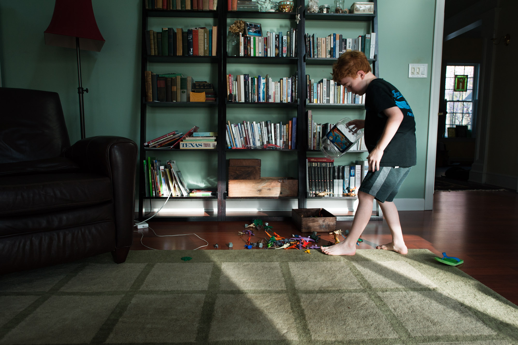 boy walks across sunlit floor - documentary family photography