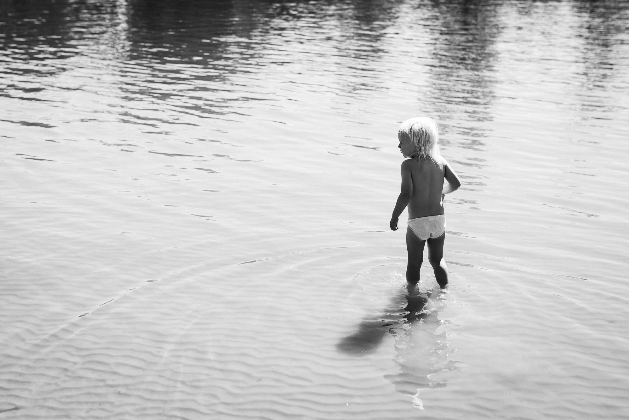 toddler wades into water - documentary family photography