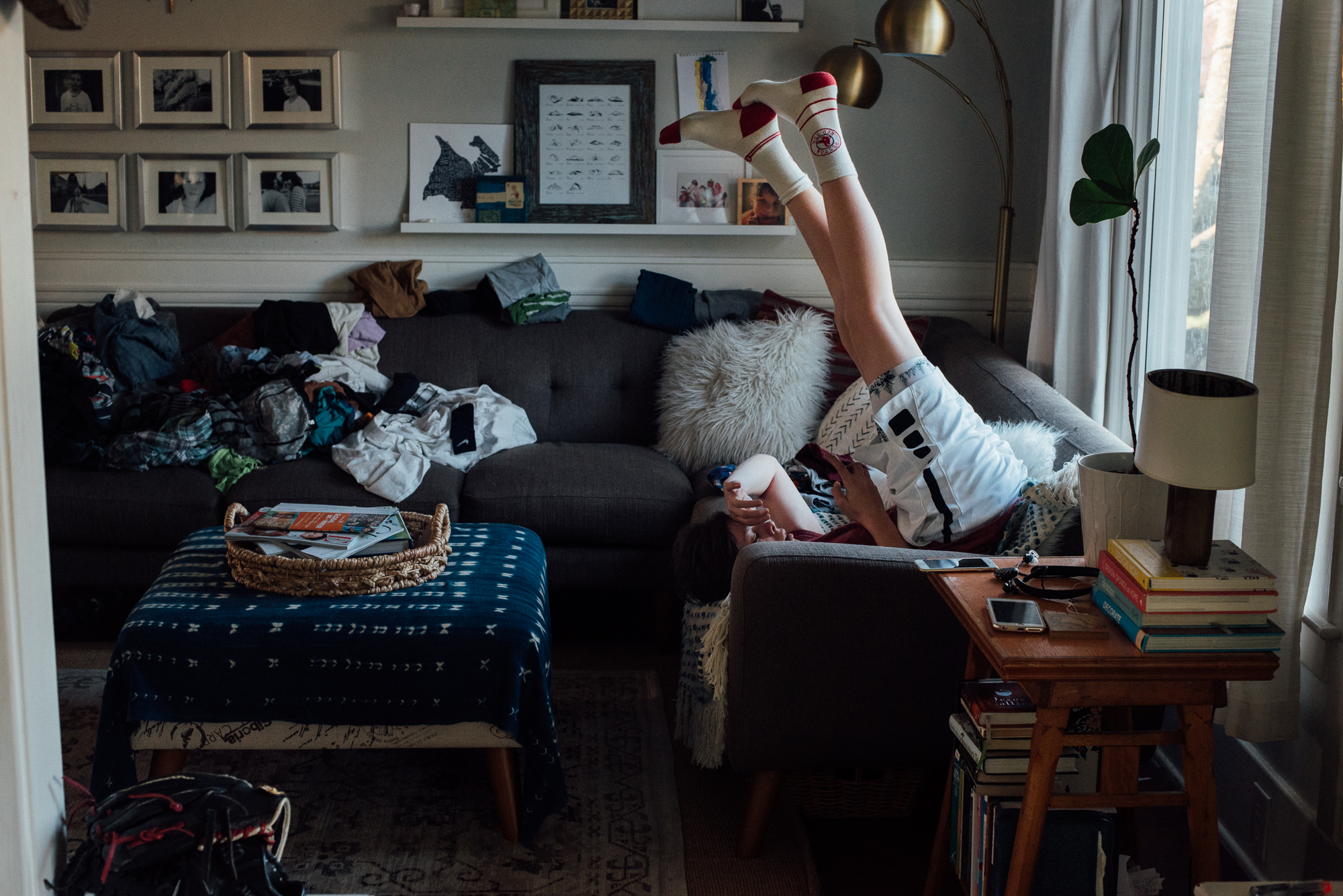 kid with feet in the air on couch - documentary family photography