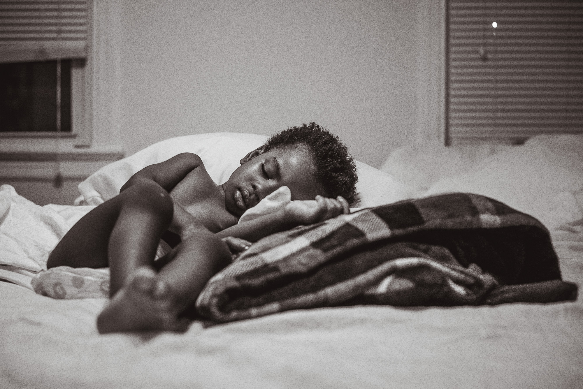 boy alone sleeping on bed - documentary family photography