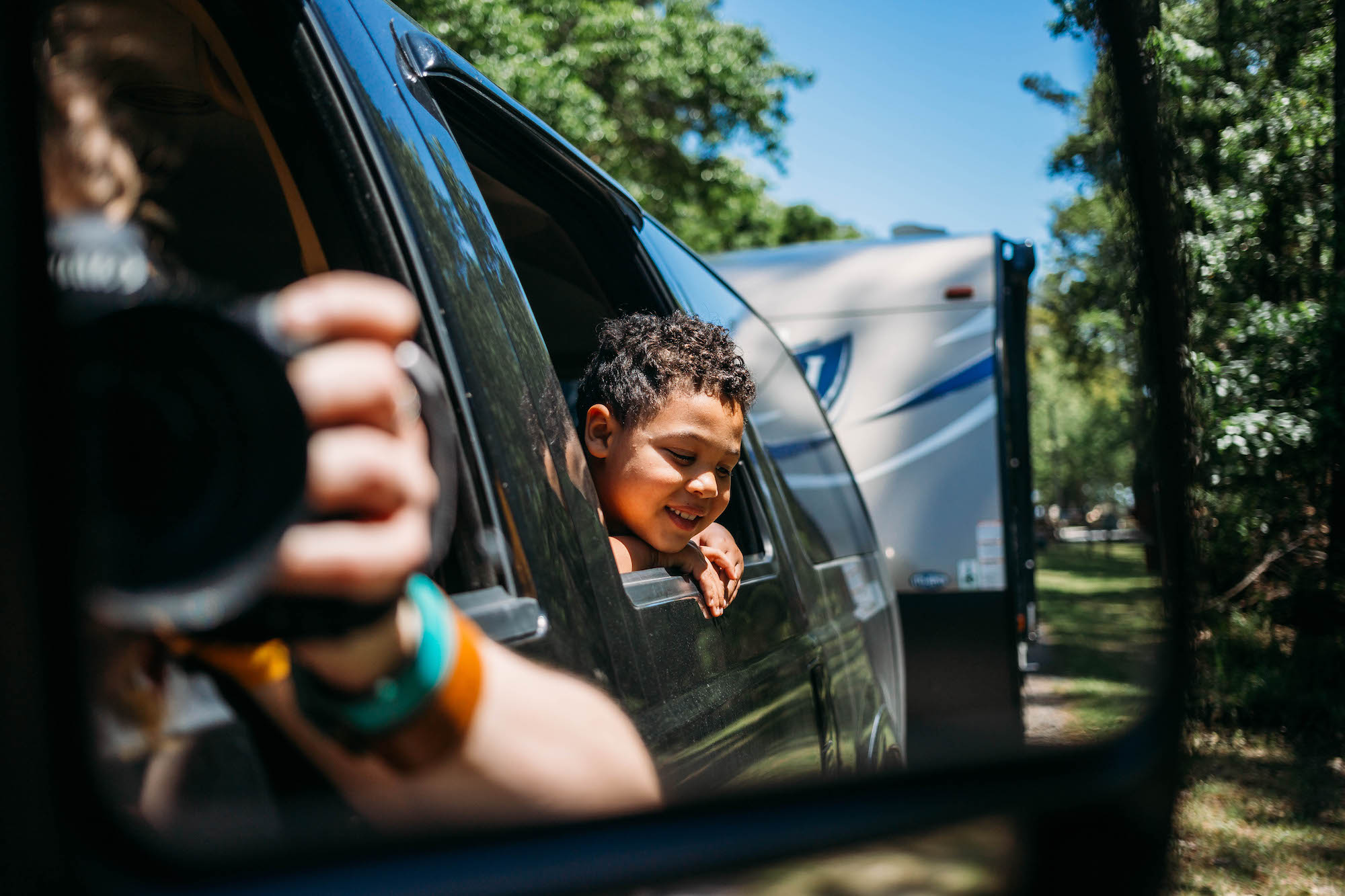 boy sticking head out of window of backseat - documentary family photography