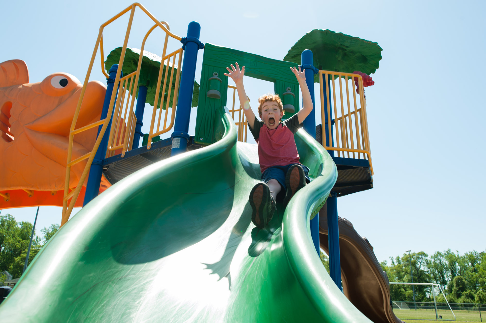 boy going down slide - documentary family photography