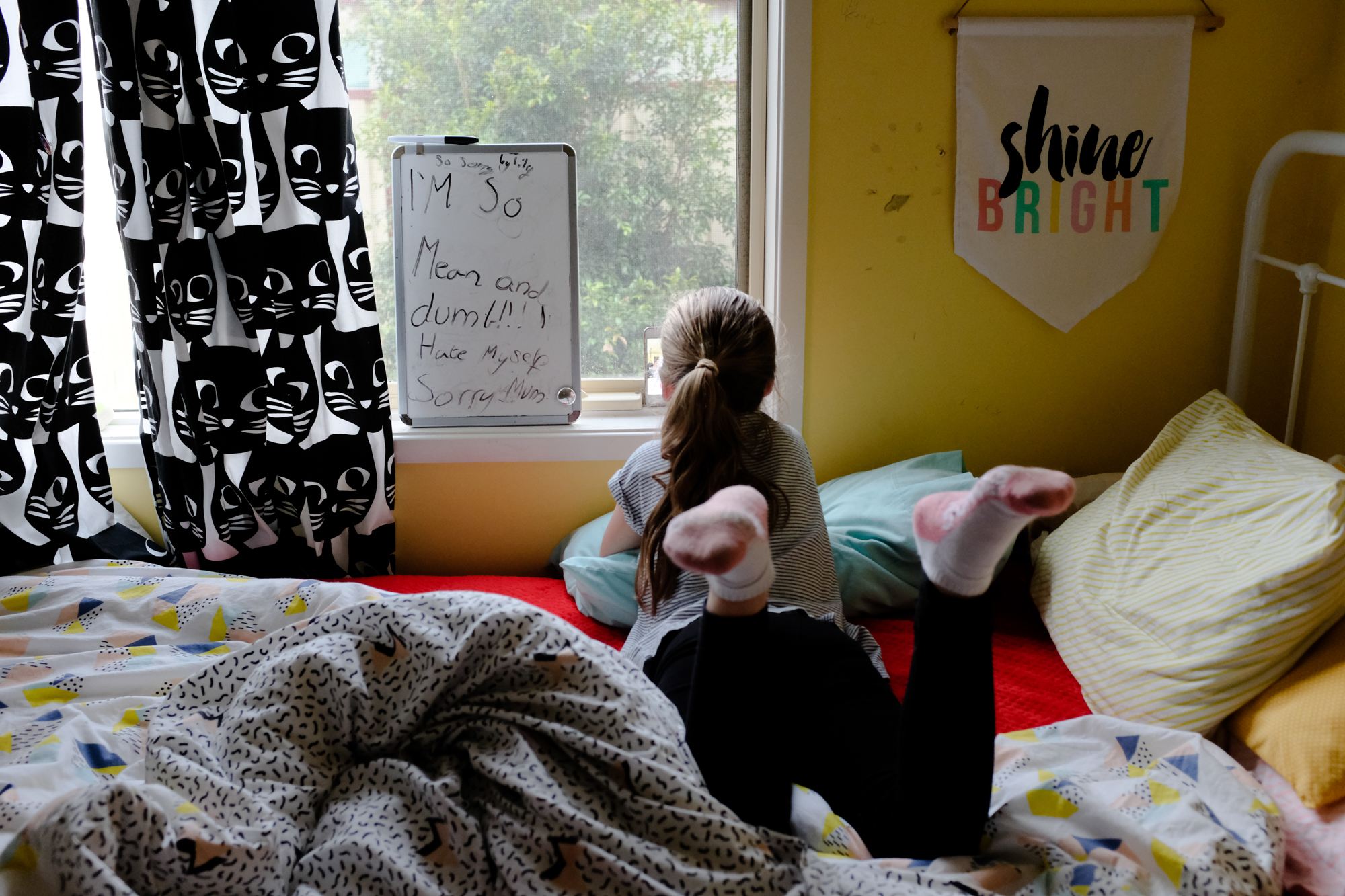 girl looking out bedroom window - Documentary family photography