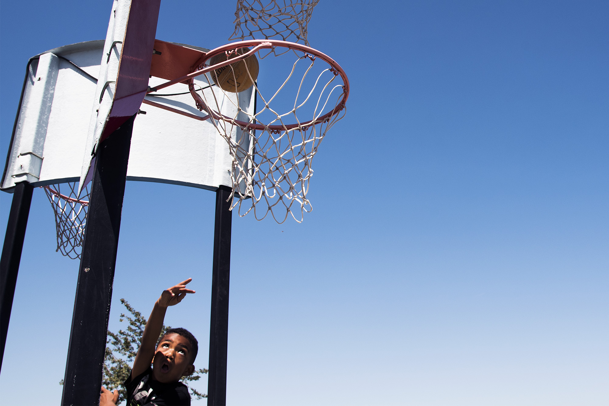 boy shooting layup - documentary family photography