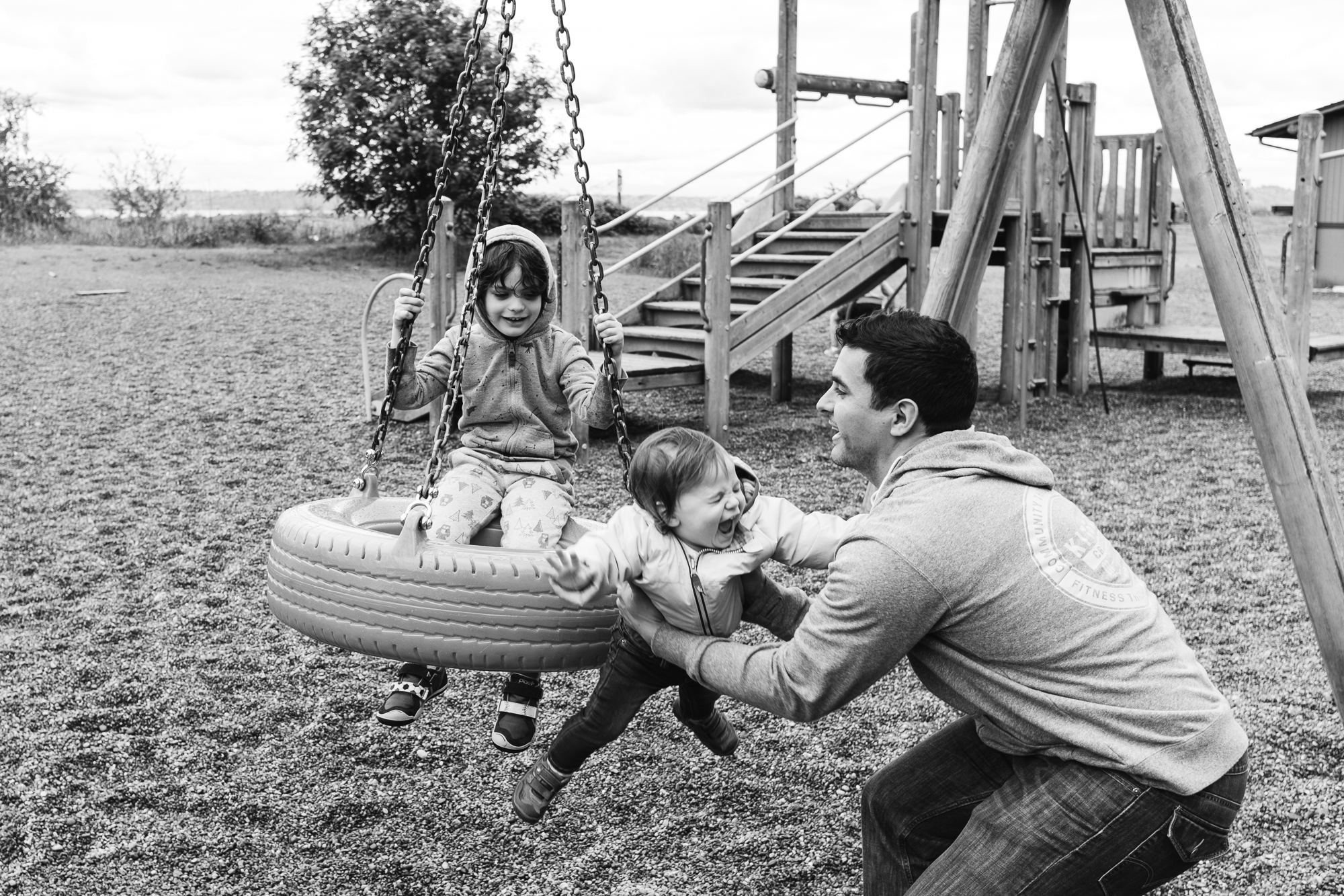 father catches baby jumping off tire swing -documentary family photography