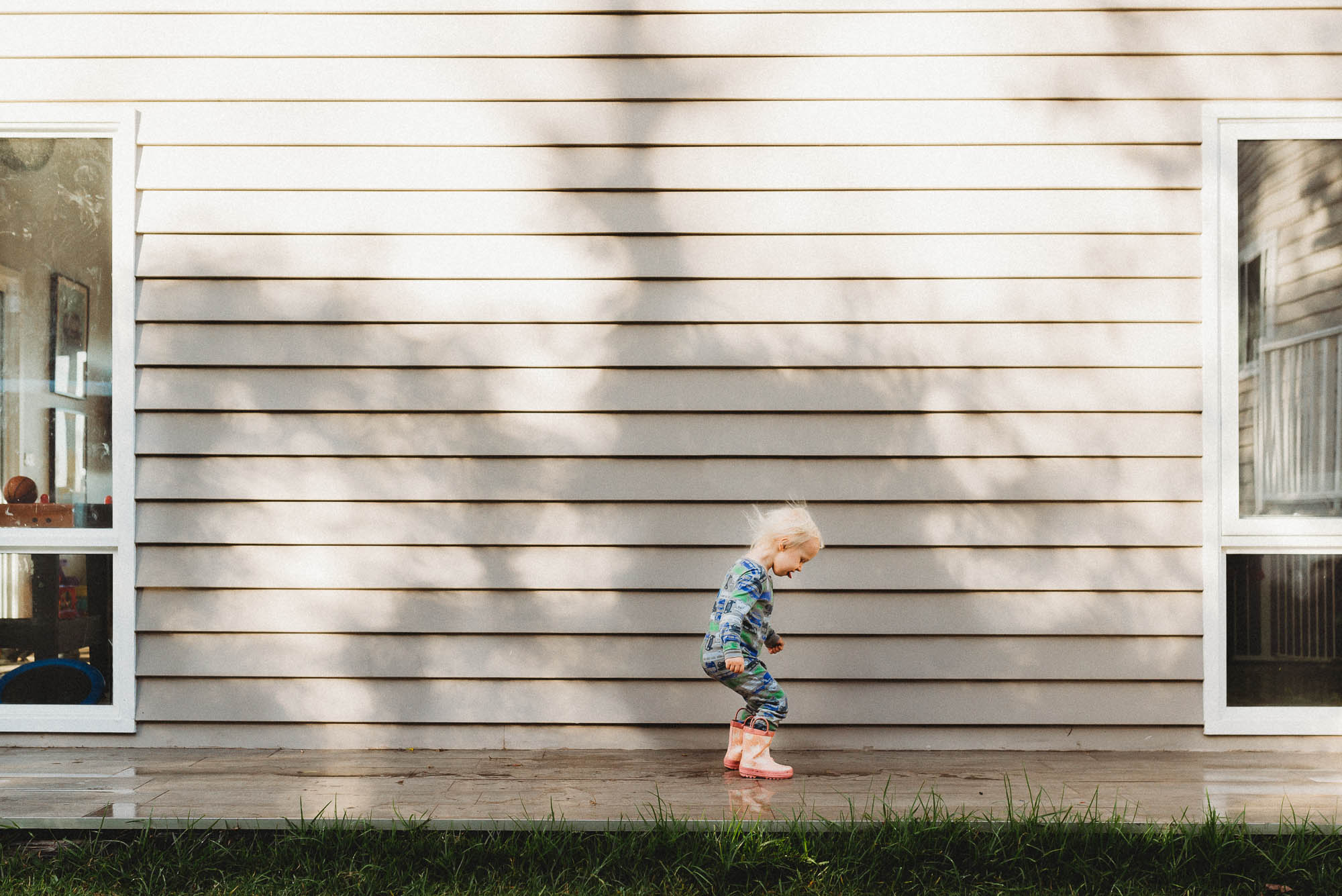 girl jumps in puddle -documentary family photography