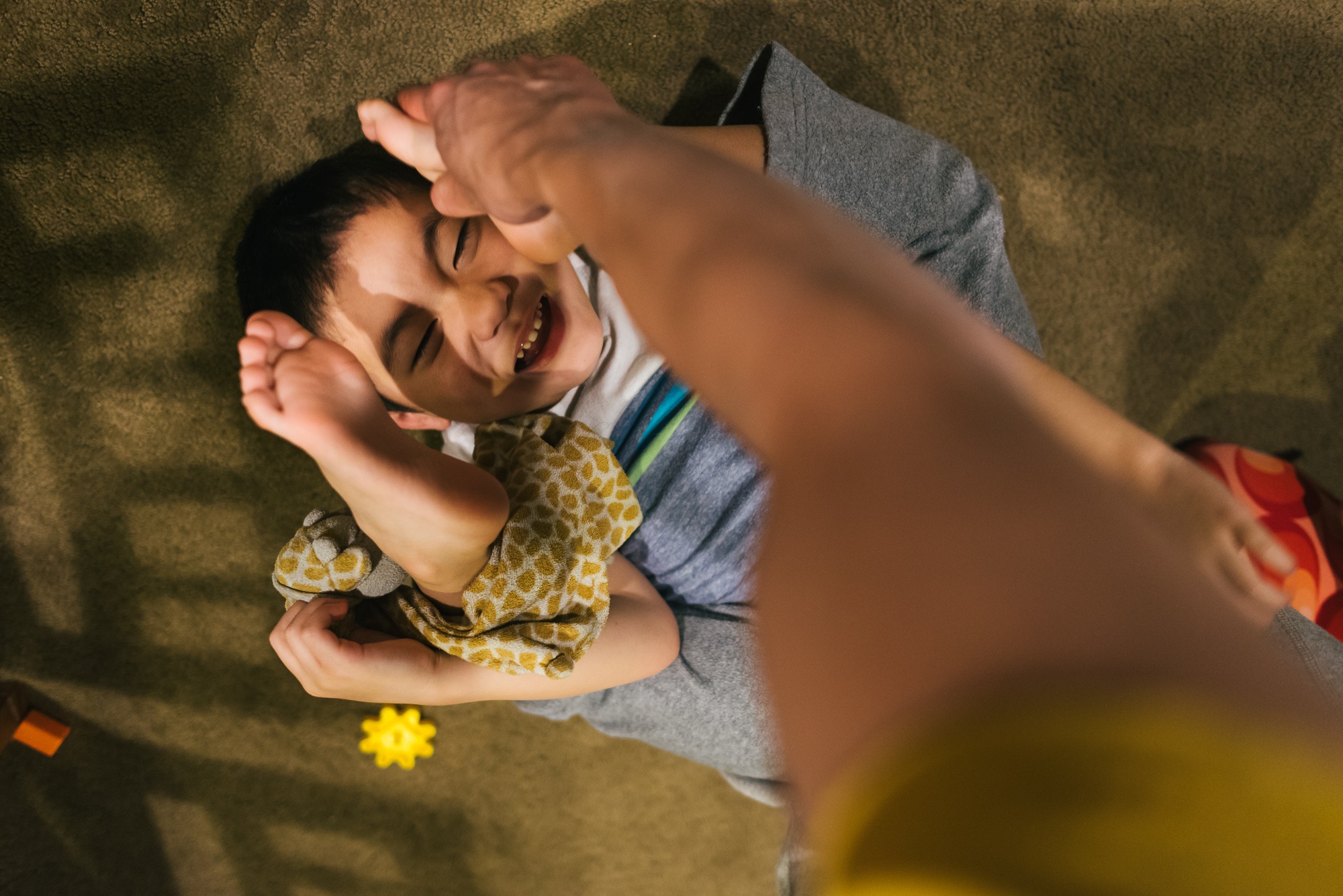 boy wrestling with parent - Documentary Family Photography