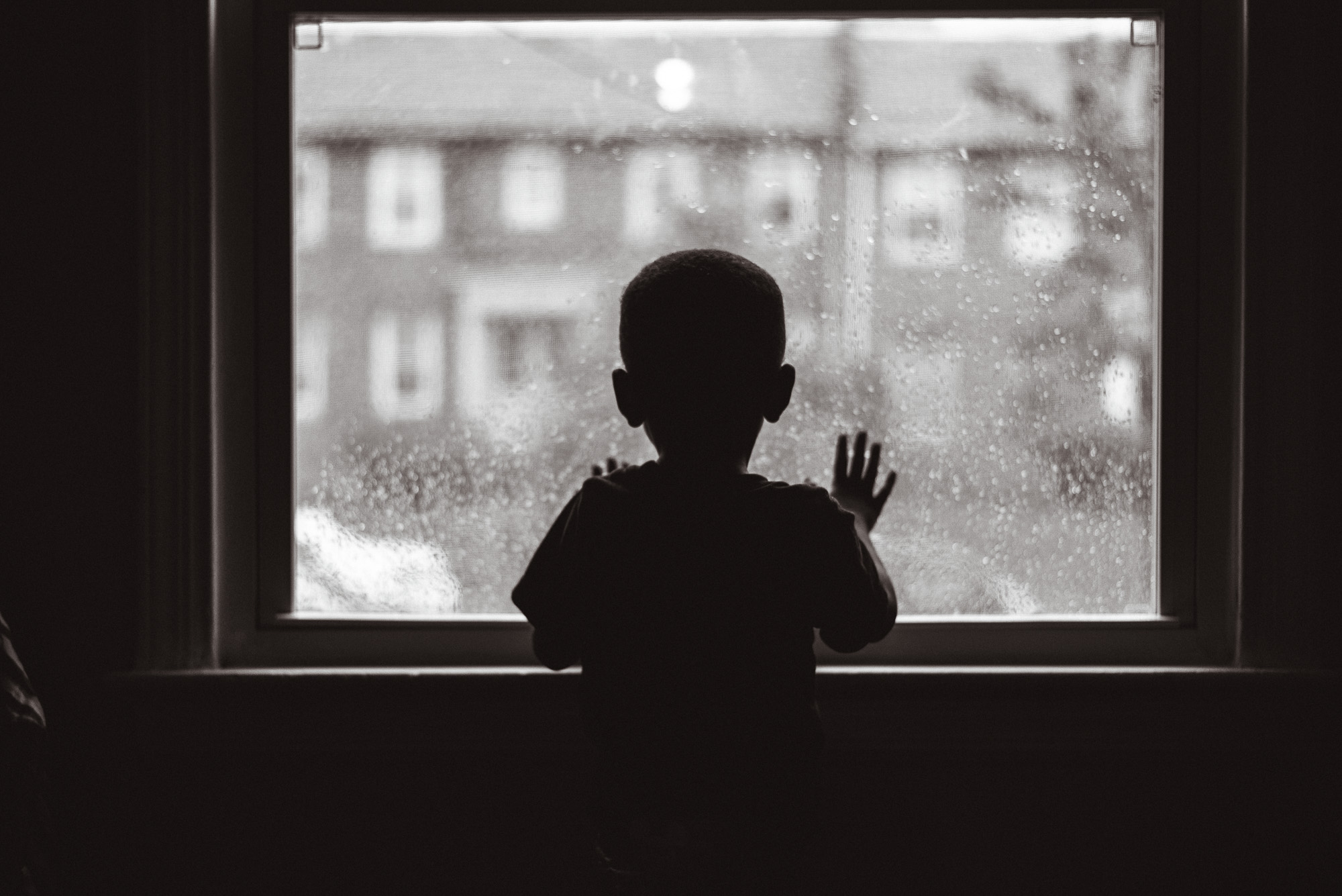 boy looking out window - documentary family photography