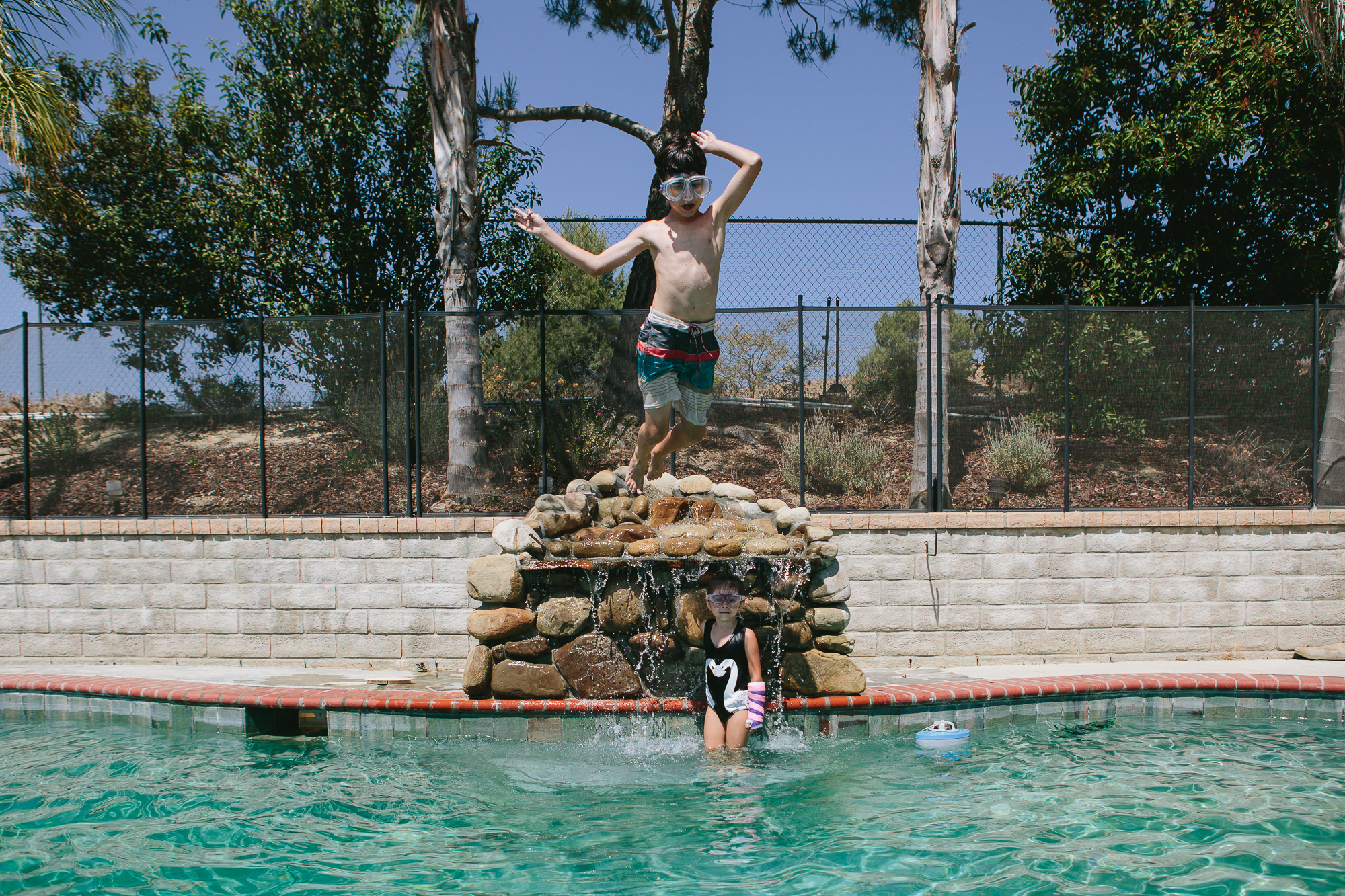 boy jumping in to pool - documentary family photography