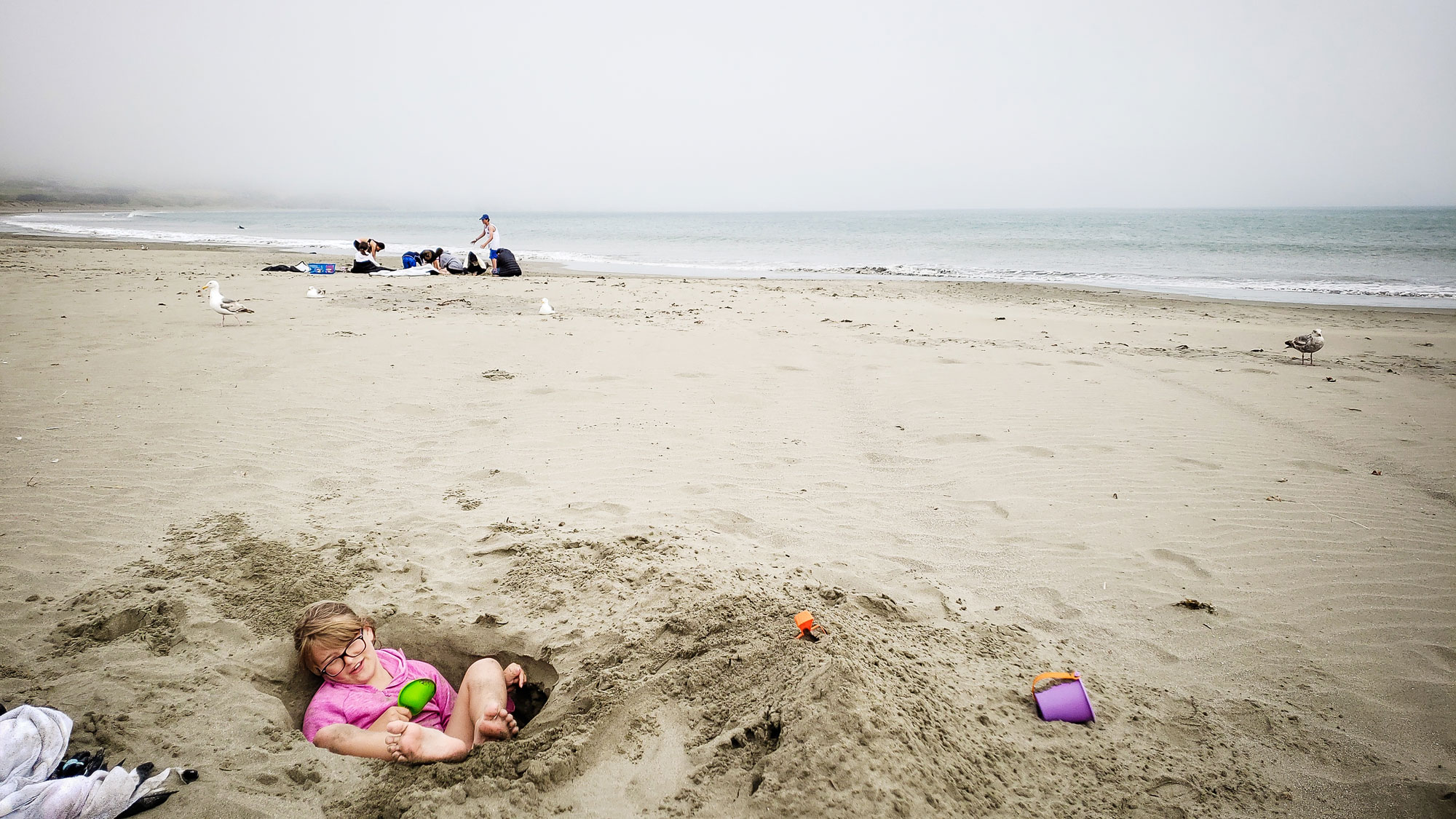 girl in sand pit on beach - documentary family photography