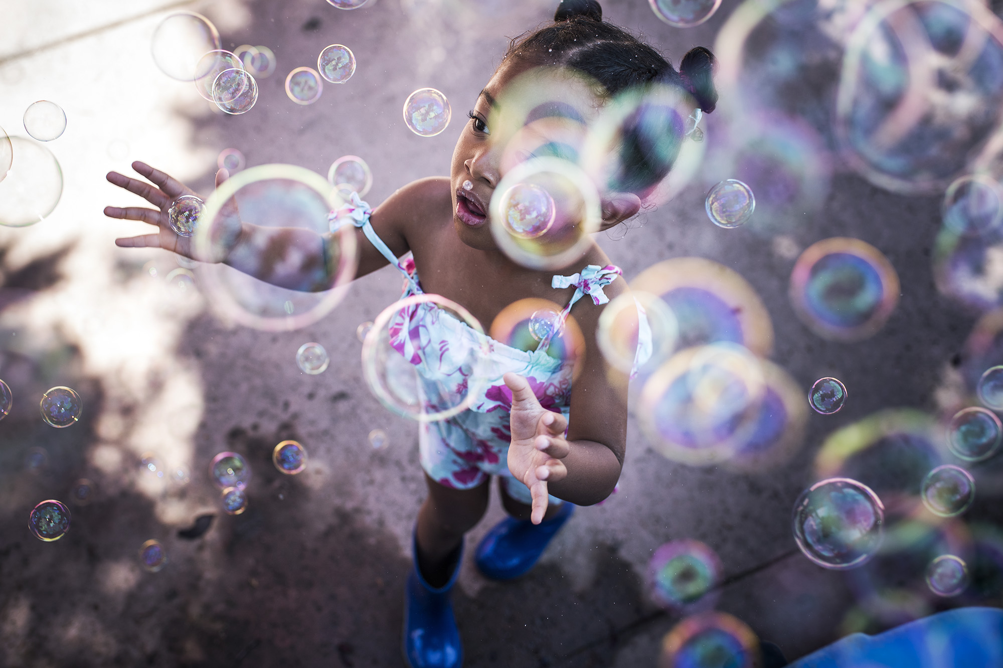 girl playing with bubbles - documentary family photography