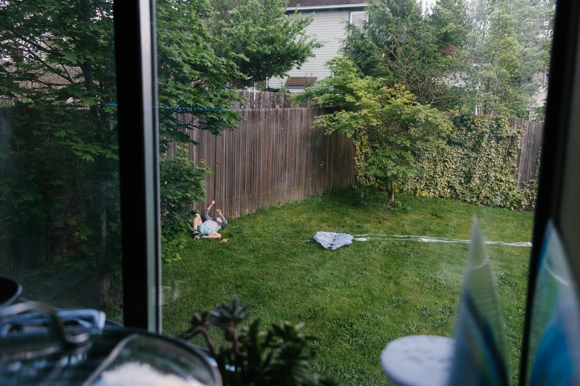 boy lounging with kite in backyard - documentary family photography