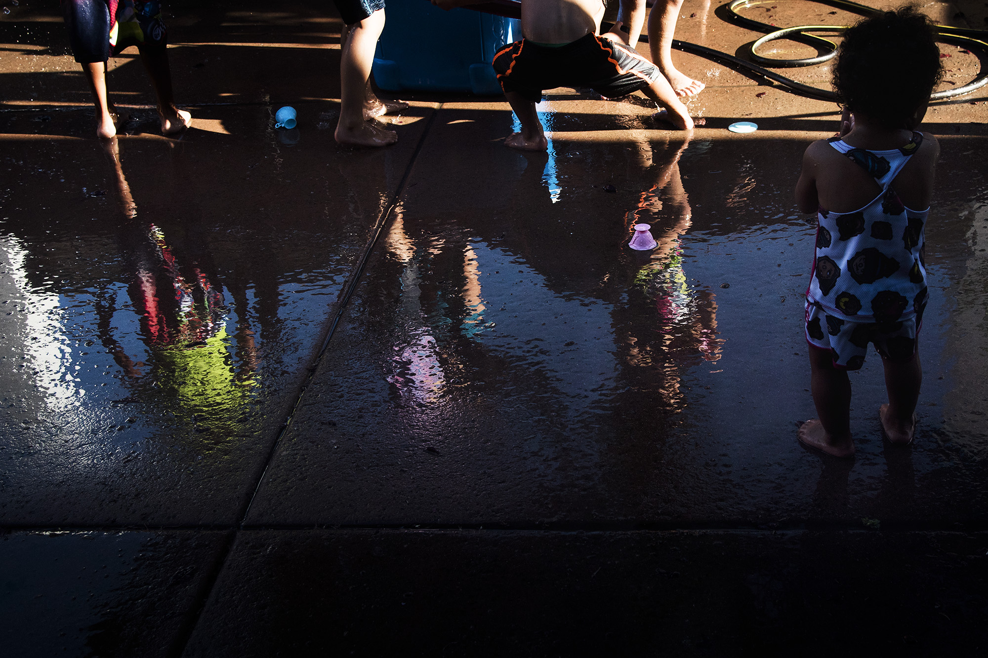 reflection of kids on wet pavement - documentary family photography