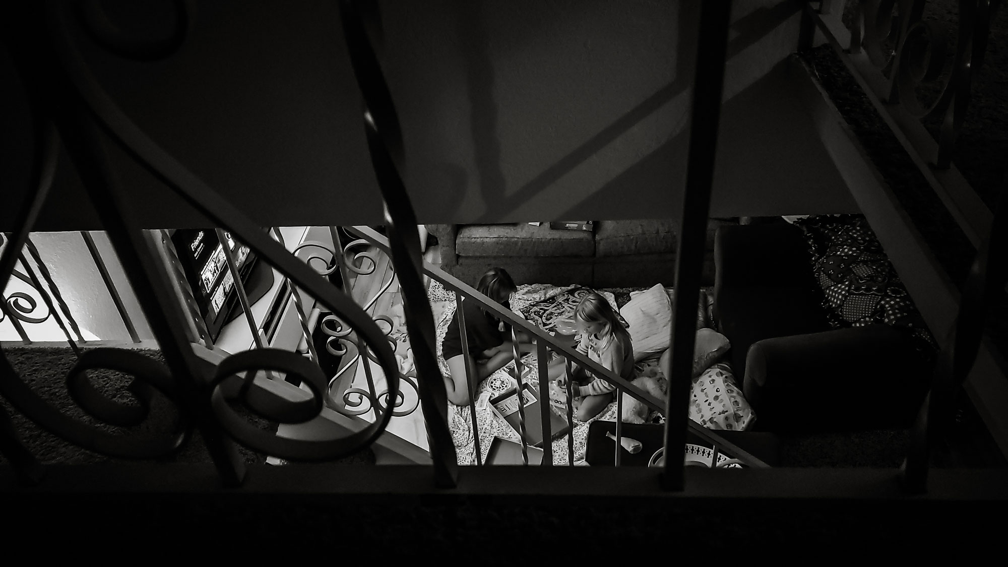 kids on living room floor as seen from staircase - documentary family photography