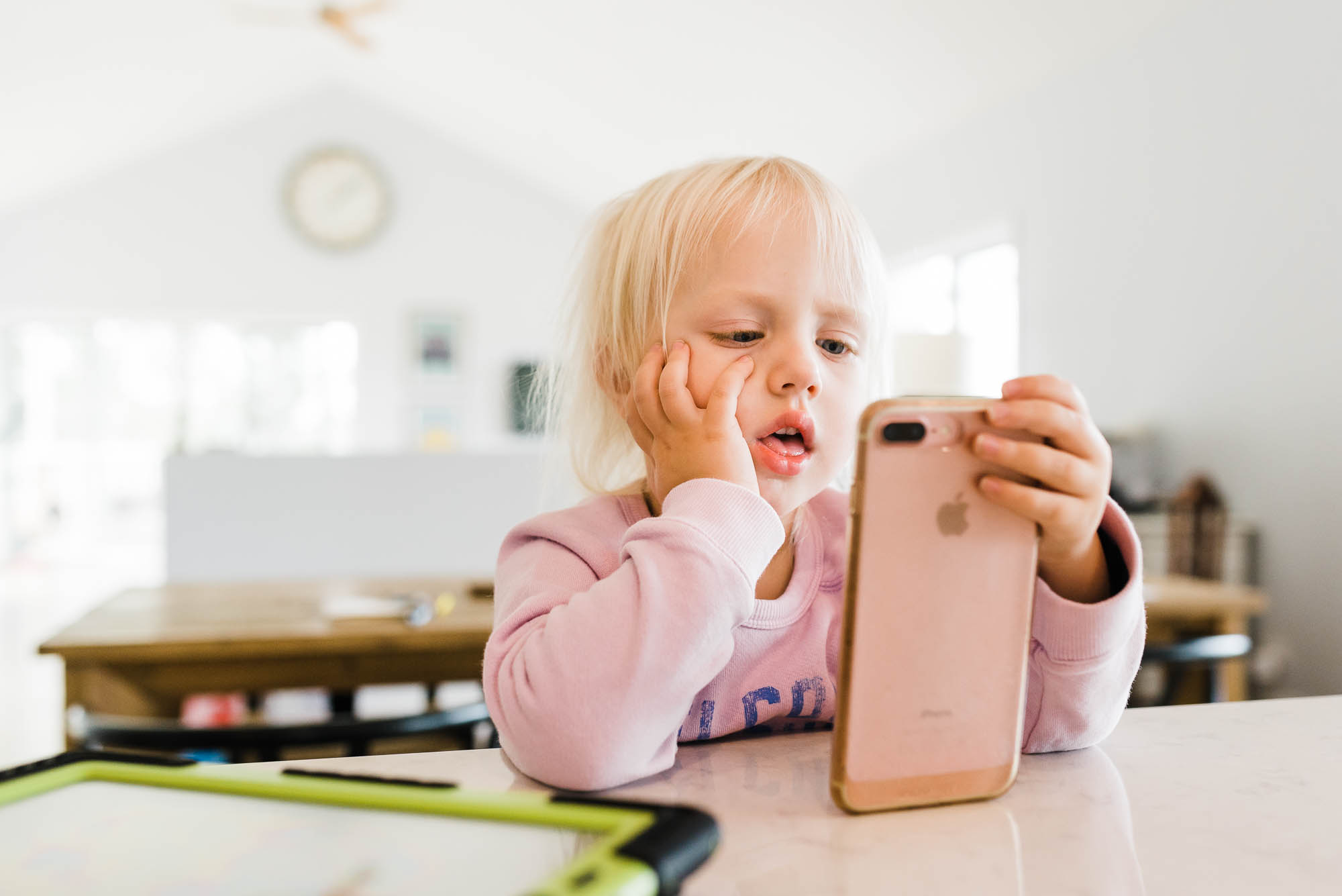 young girl looking at phone - documentary family photography