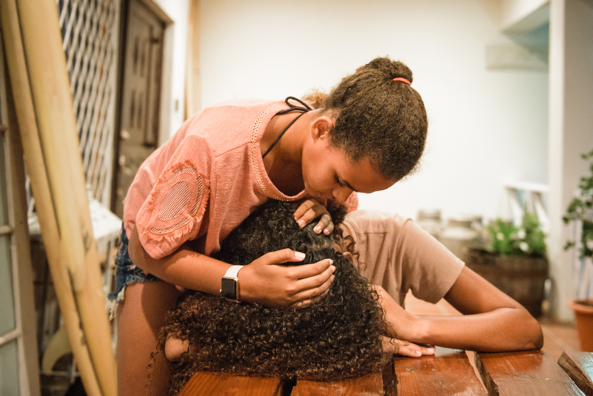 girl examining sister's scalp - Documentary Family Photography