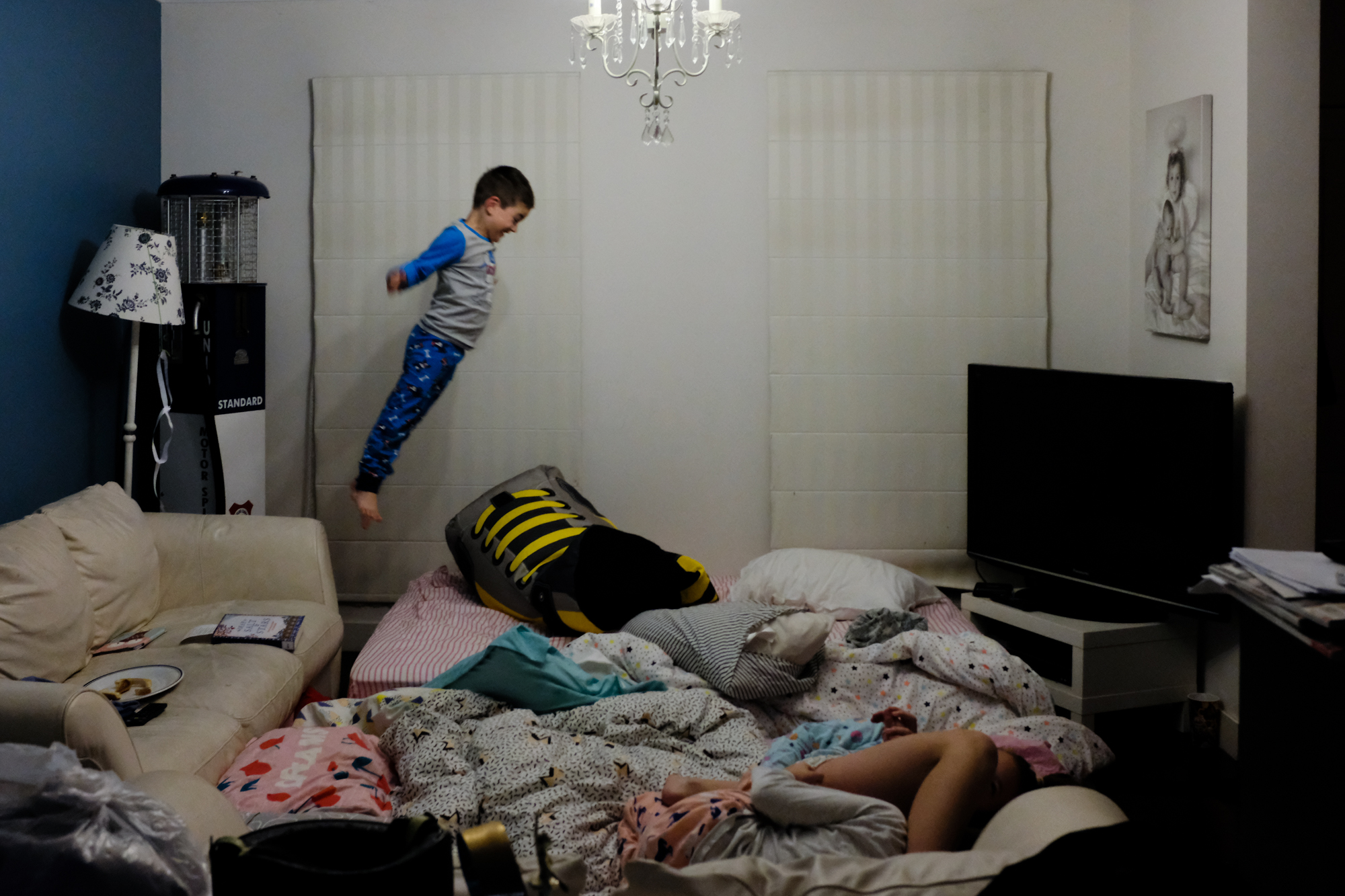 kid jumping into blankets - Documentary Family Photography