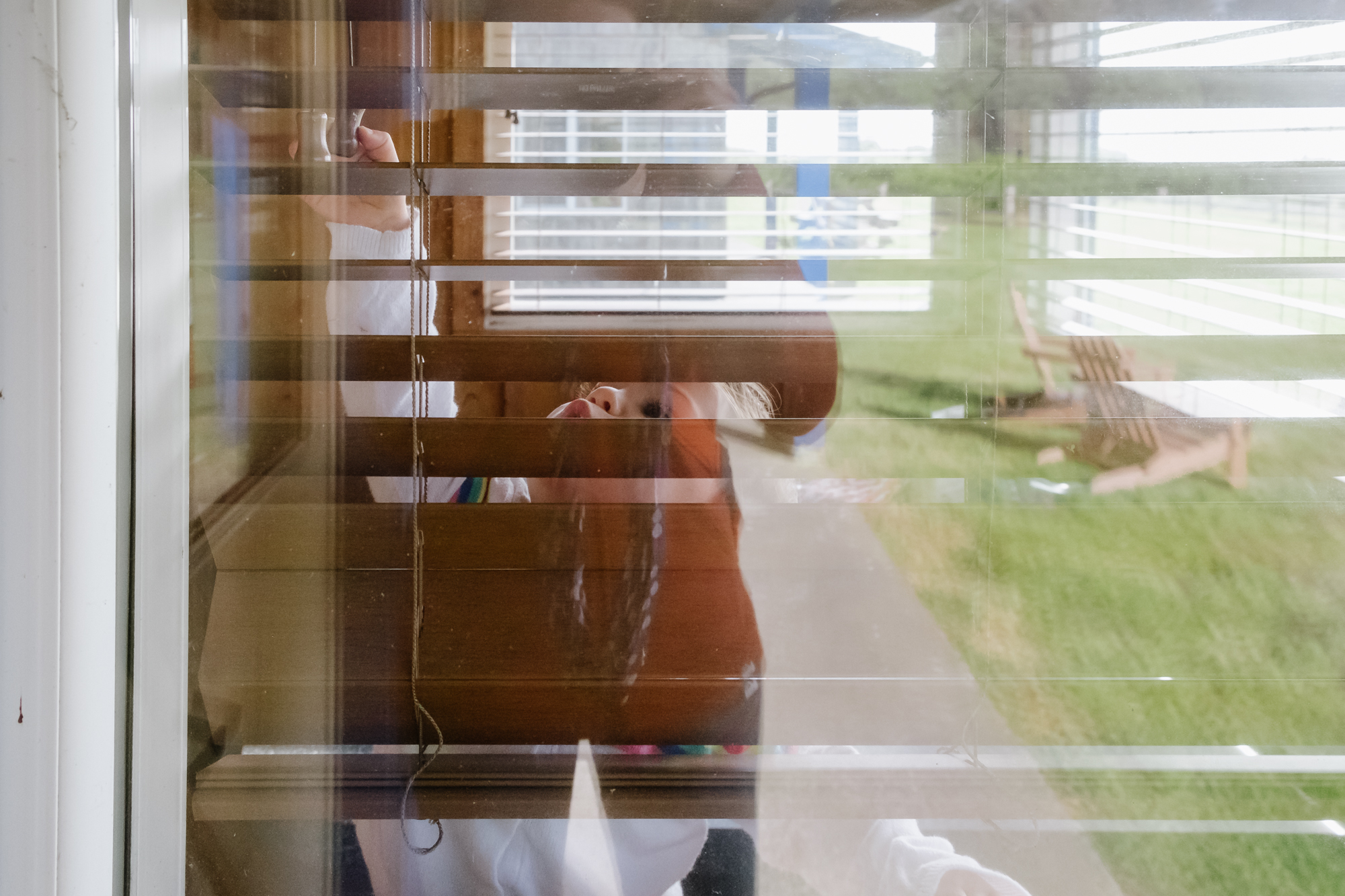 baby playing with blinds - documentary family photography