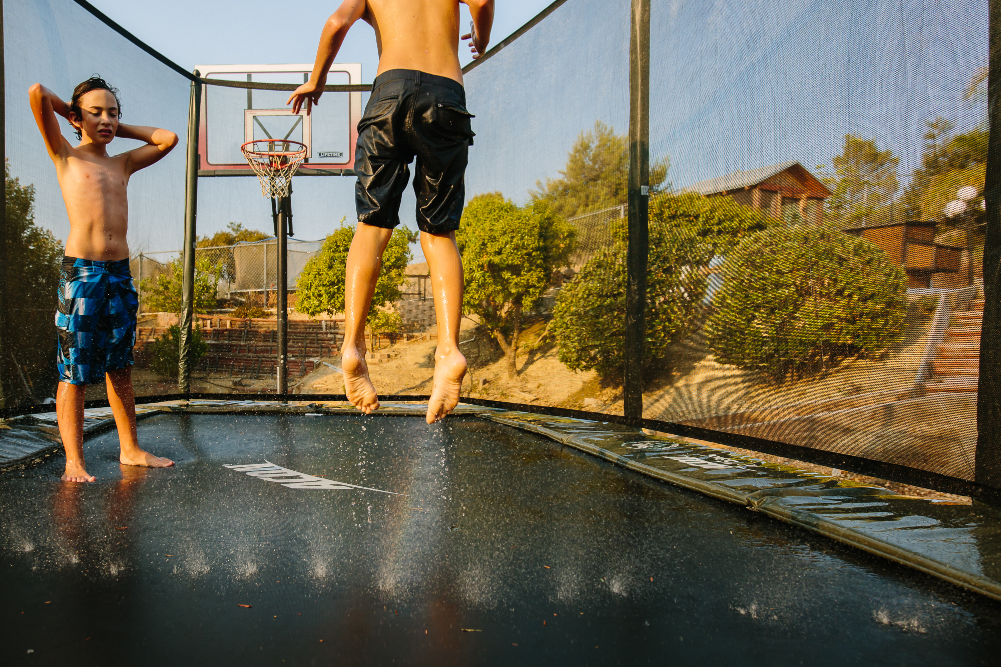boys jumping on trampoline - documentary family photography