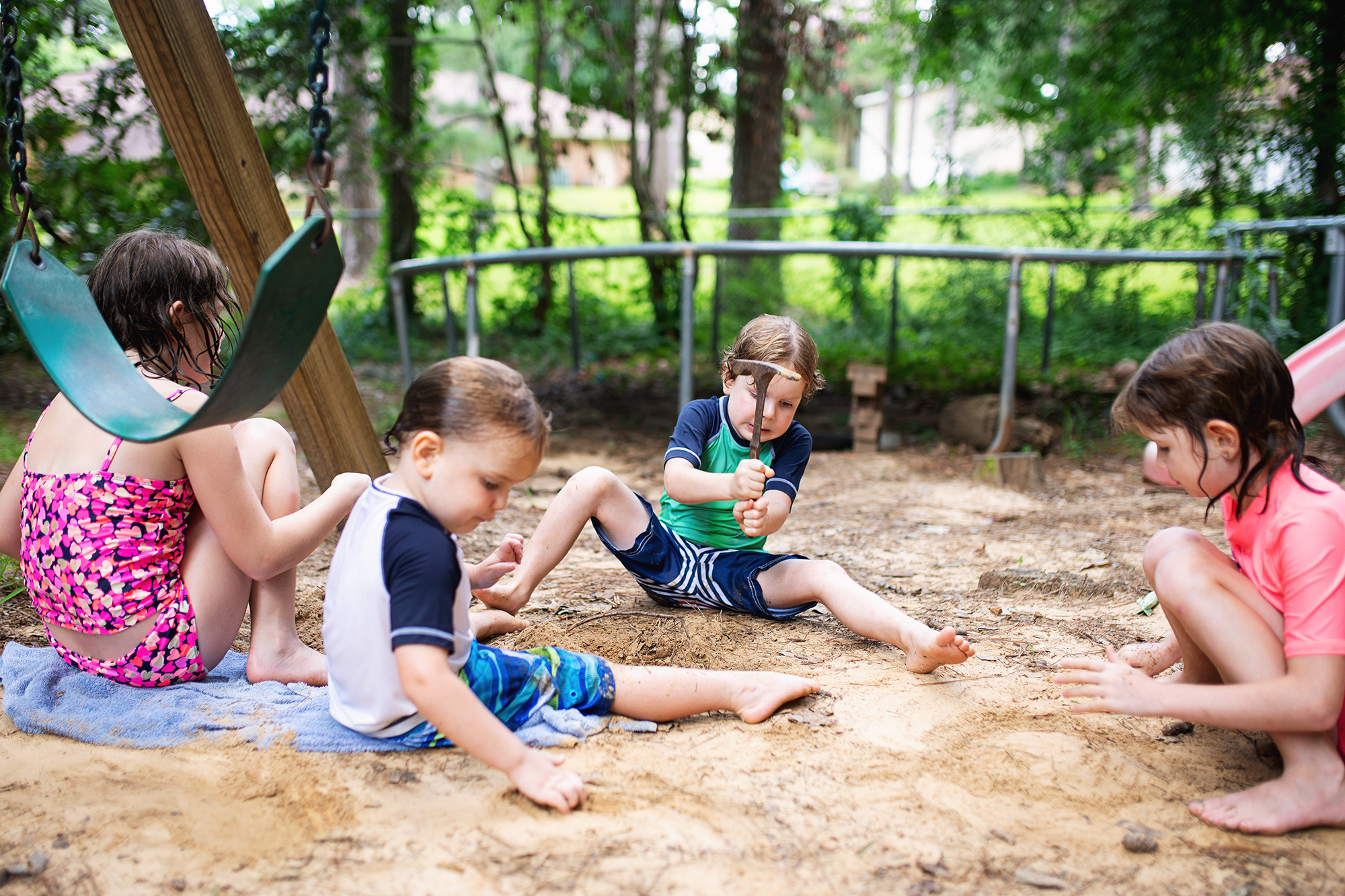 kids playing in sand under swingset - documentary family photography