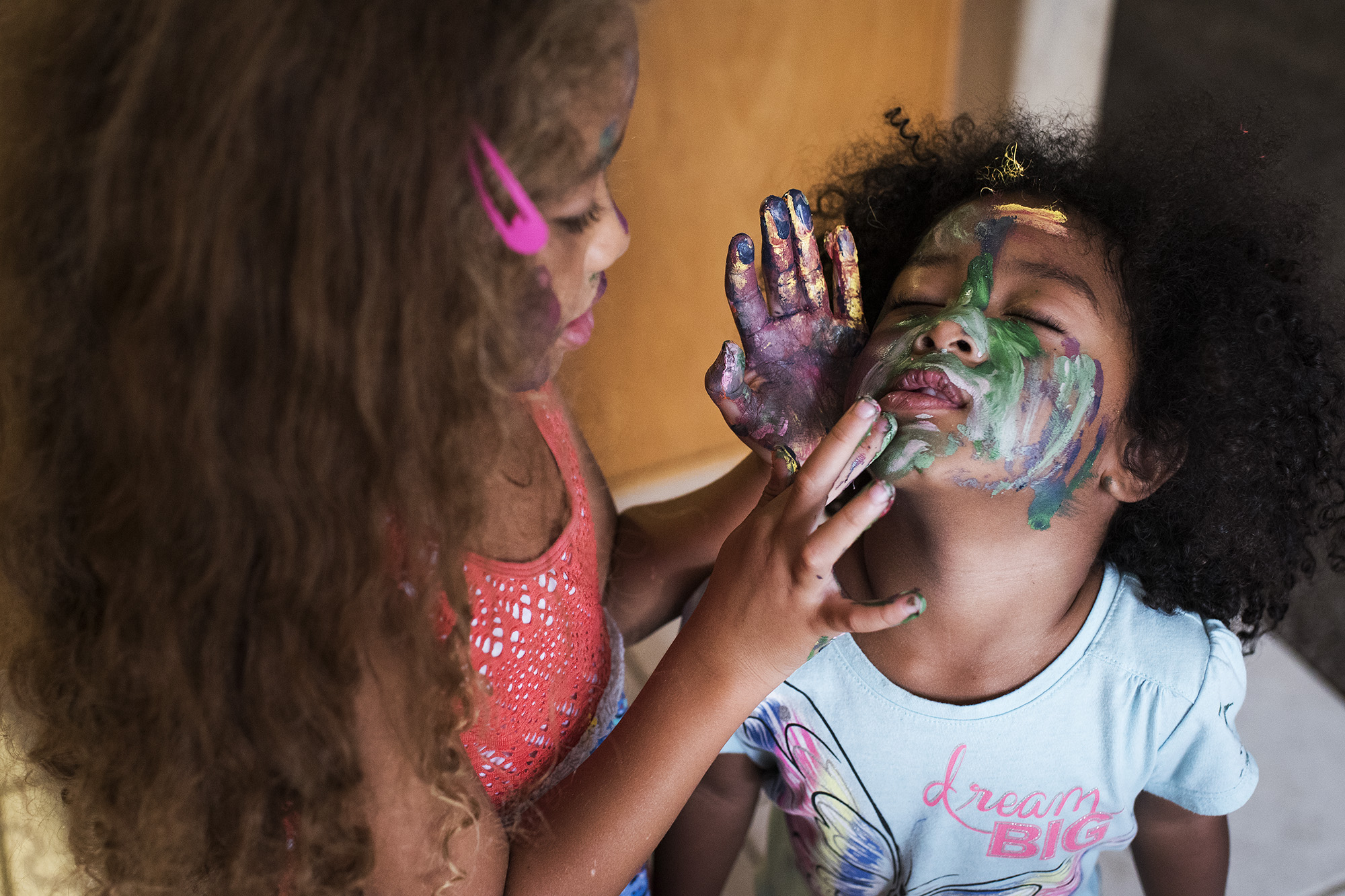 girl painting sister's face - documentary family photography