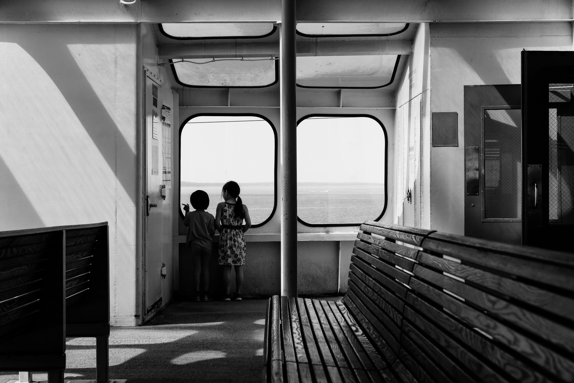 kids look out window on ferry - documentary family photography