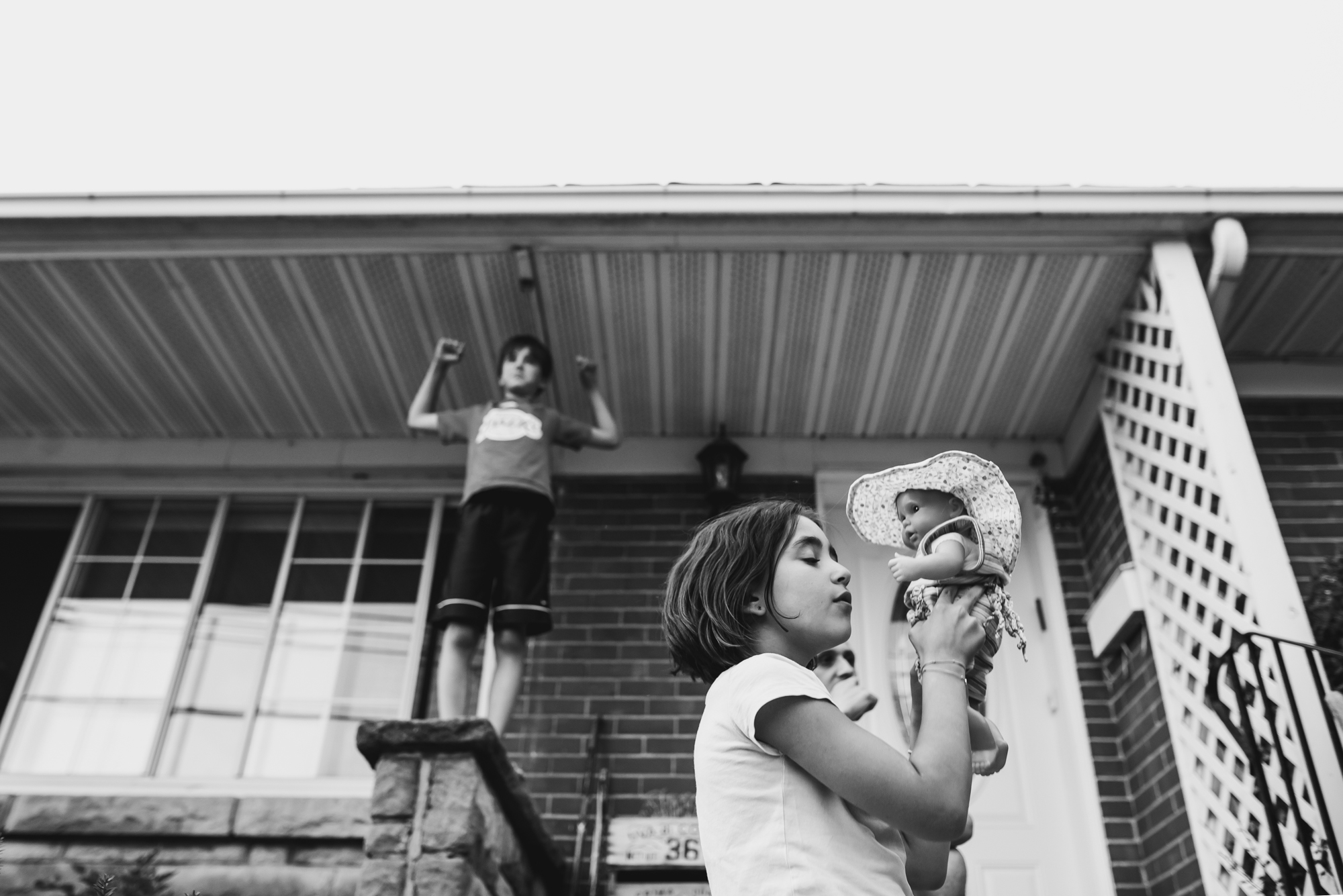 girl playing with doll on front porch - documentary family photography