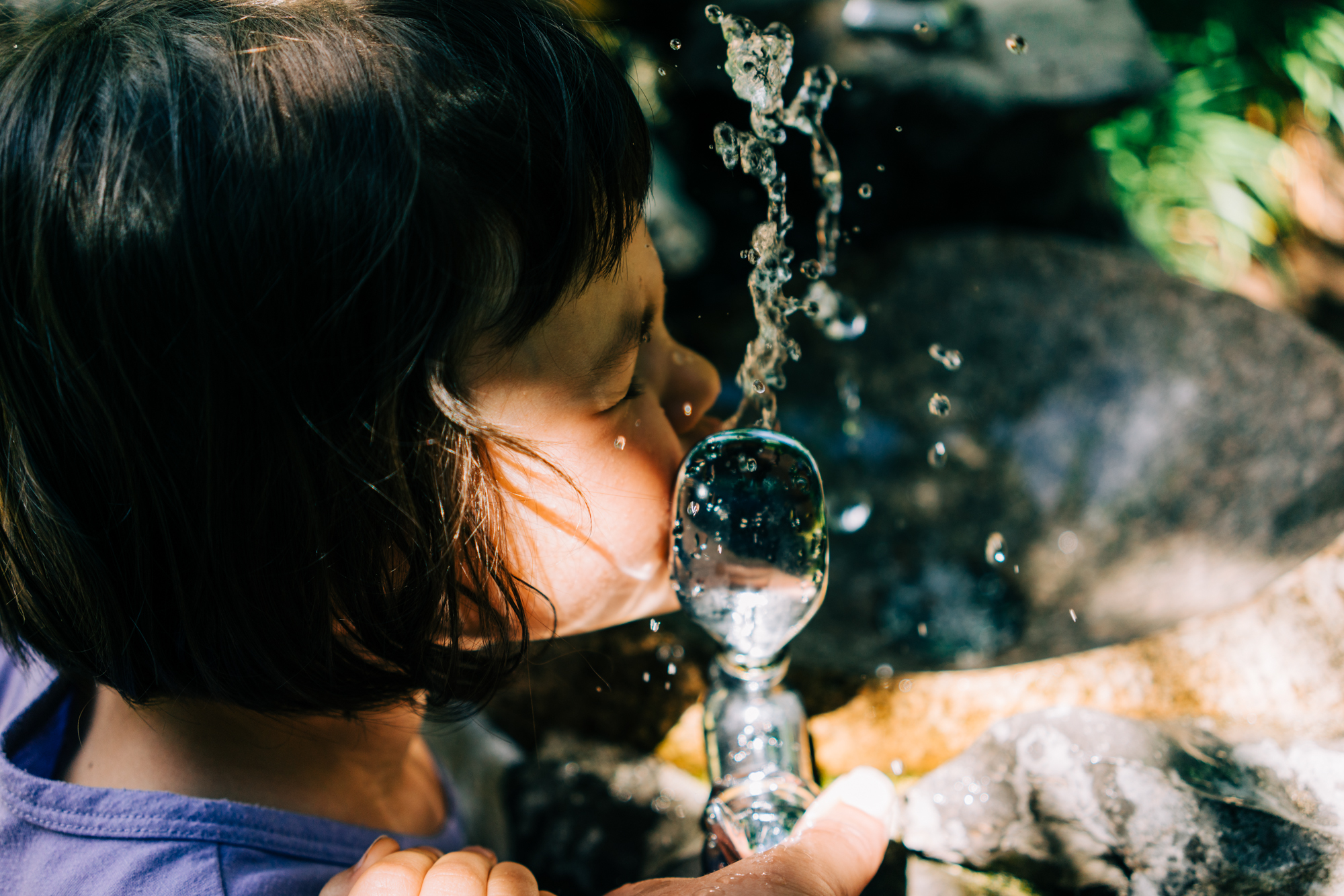 girl drinking from water fountain - documentary family photography