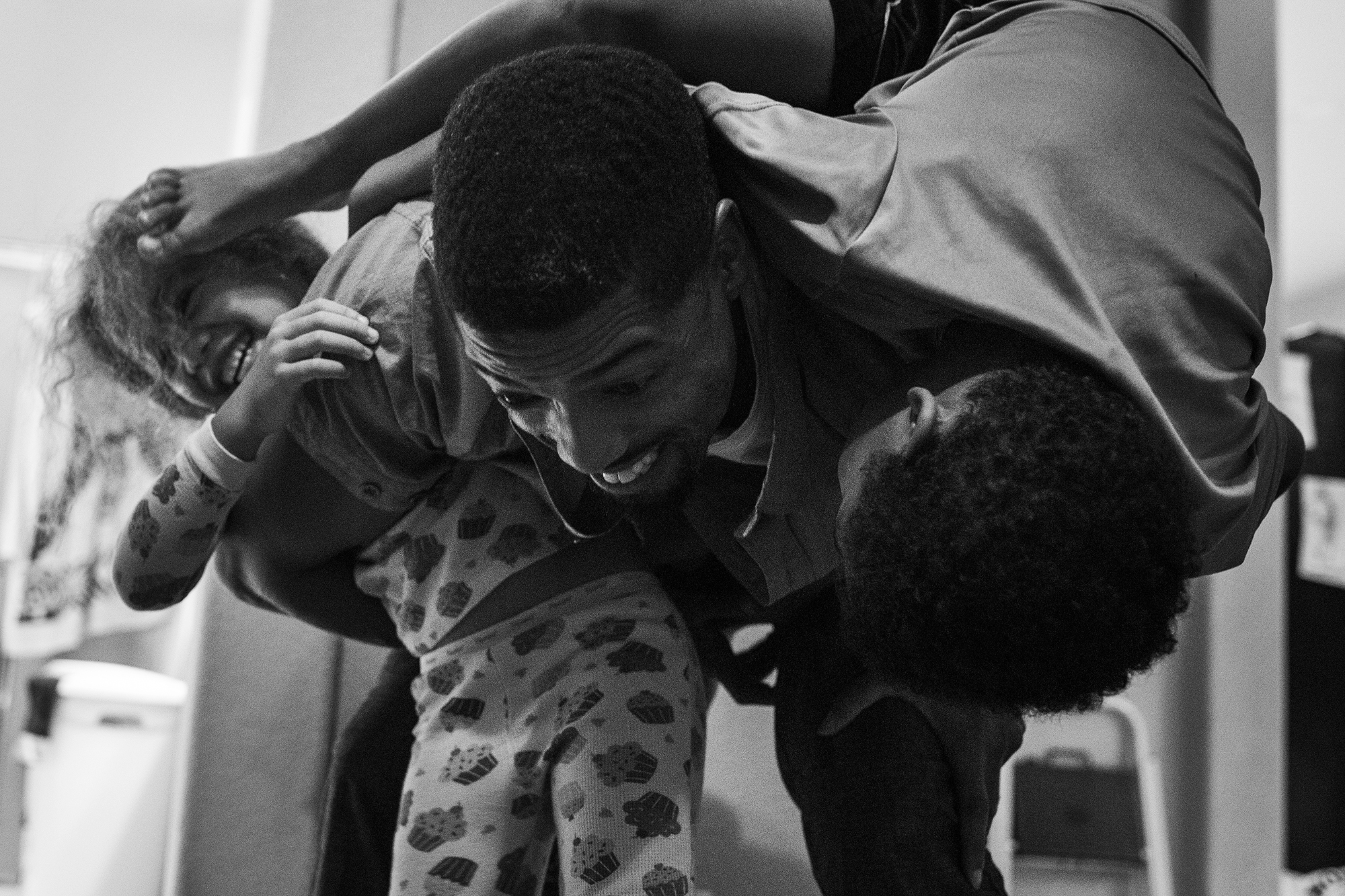 father wrestling with children - documentary family photography