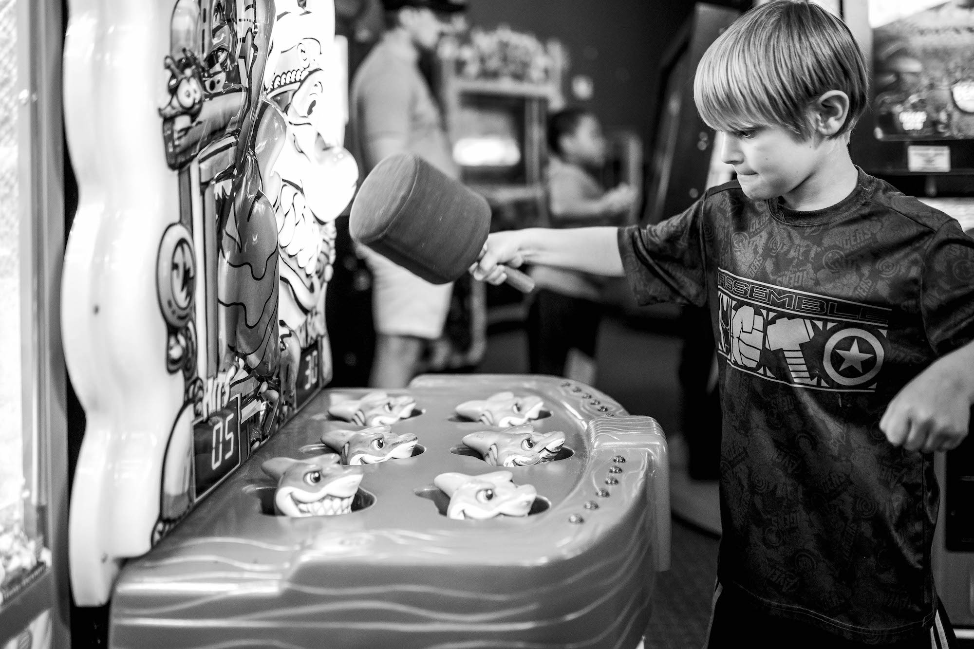 child playing whack a mole - documentary family photography